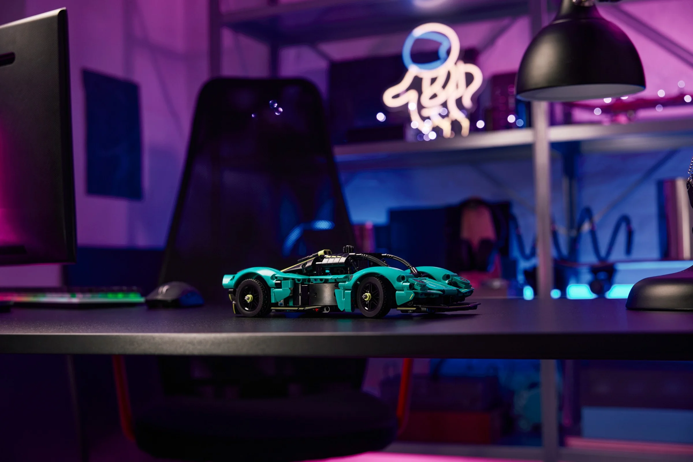 Aston Martin Valkyrie LEGO Technic, un model elegant pe un birou cu iluminare ambientală.