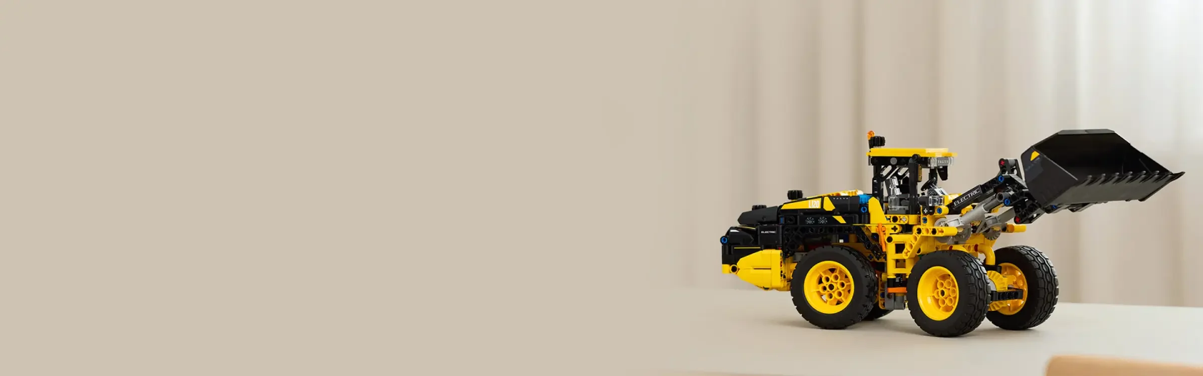 Încărcătorul frontal electric Volvo L120 LEGO Technic galben și negru. Design detaliat, aspect realist.