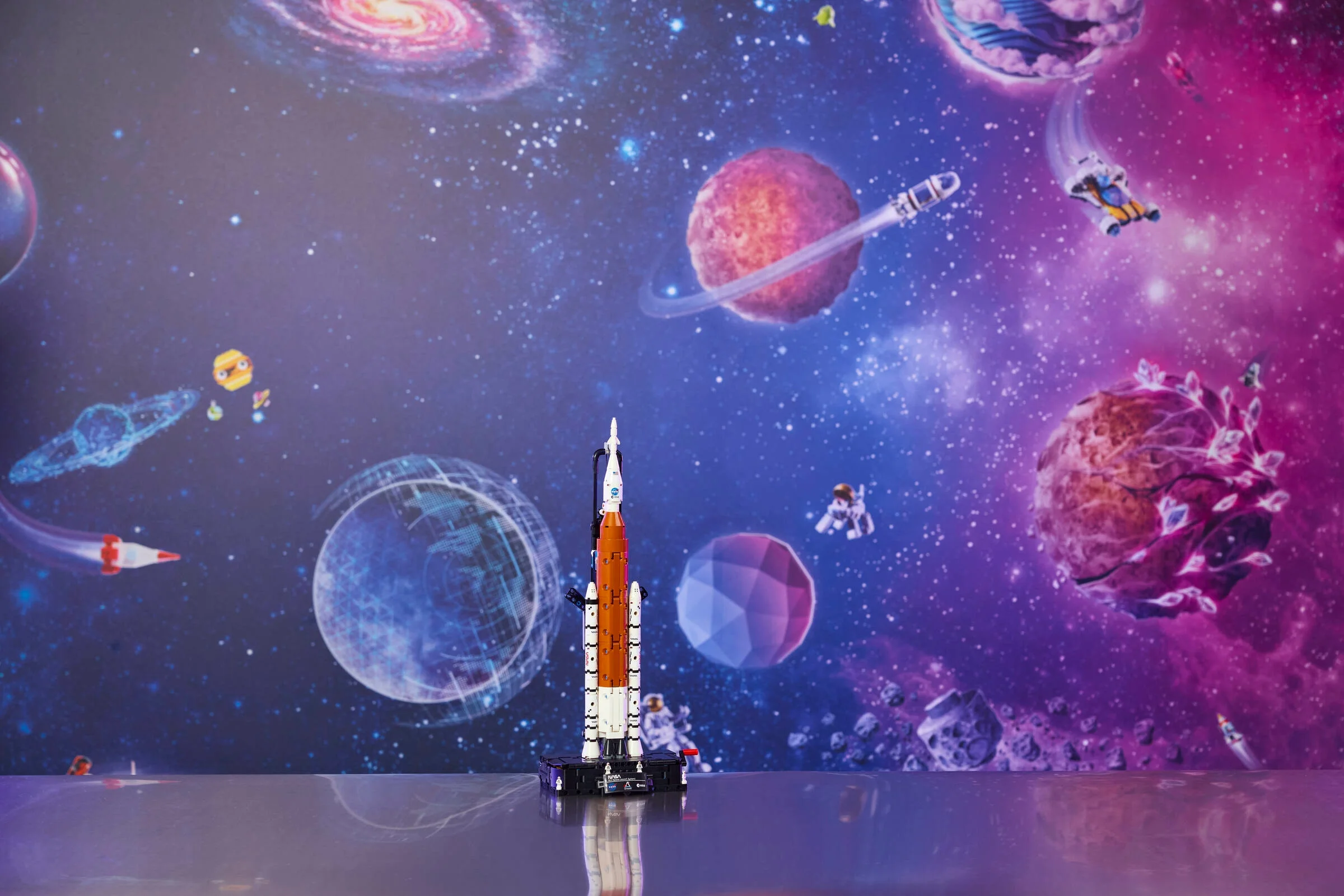 Racheta Artemis SLS LEGO stă elegant pe un fundal spațial colorat.
