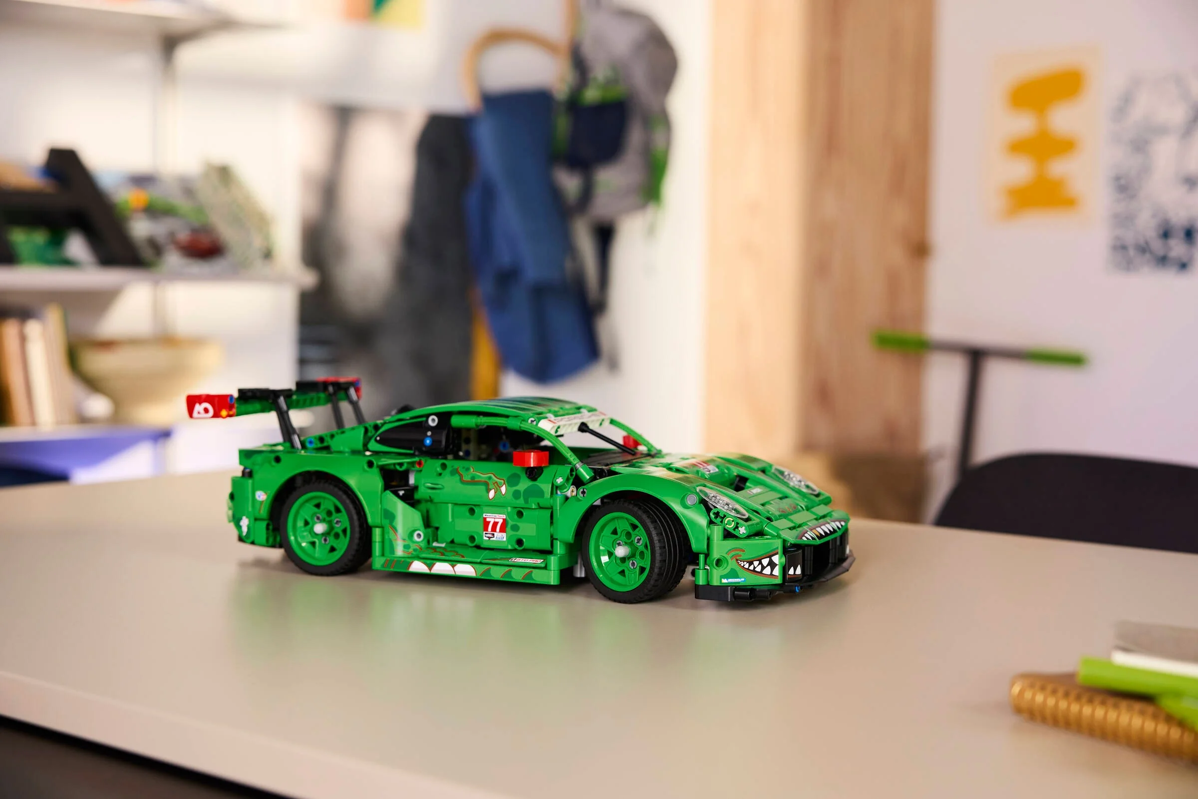 Modelul LEGO Porsche 911 GT3 R REXY AO Racing, verde și detaliat, pe o masă.