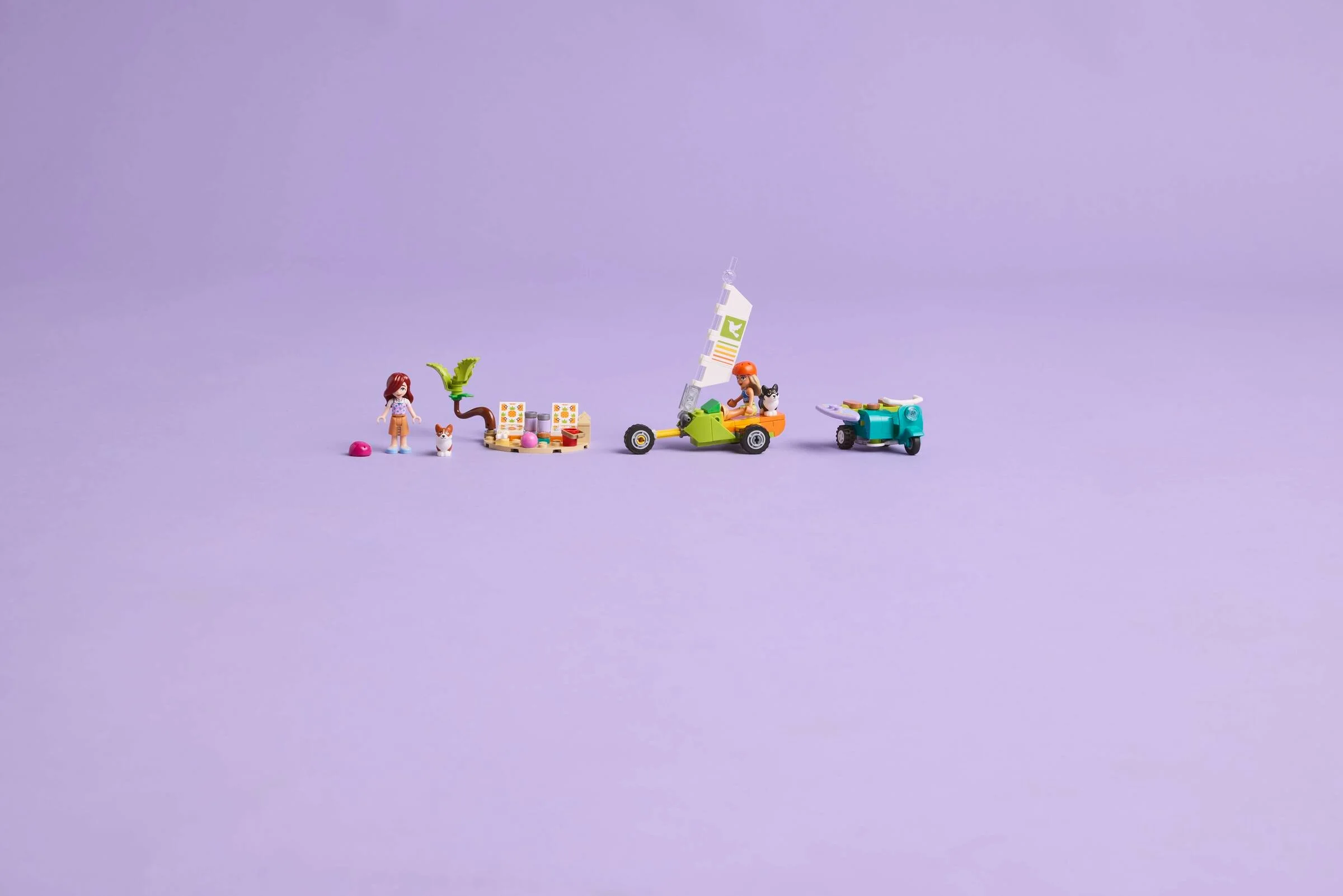 Imagine cu setul LEGO Friends 42641. Prezintă minifigurinele și vehiculele pe un fundal violet.