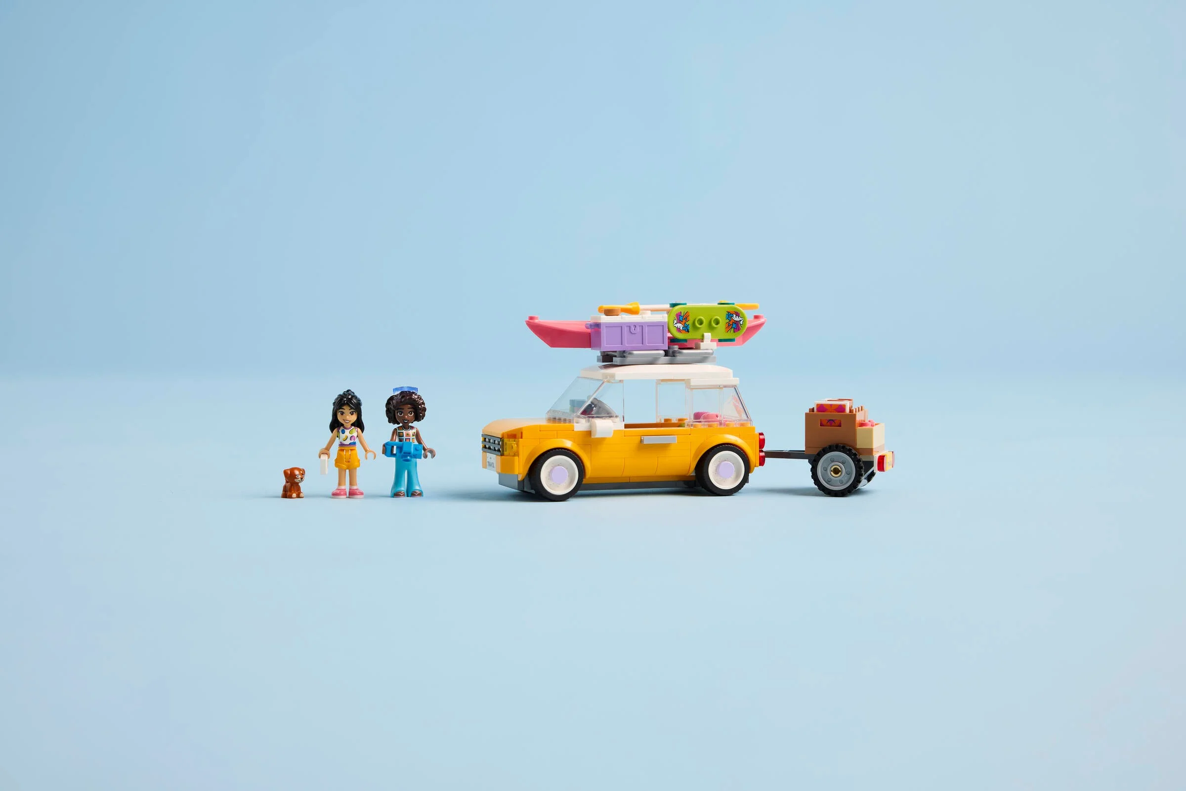 Setul LEGO Friends 42659: mașină galbenă de excursie cu remorcă, kayak și minifigurine.