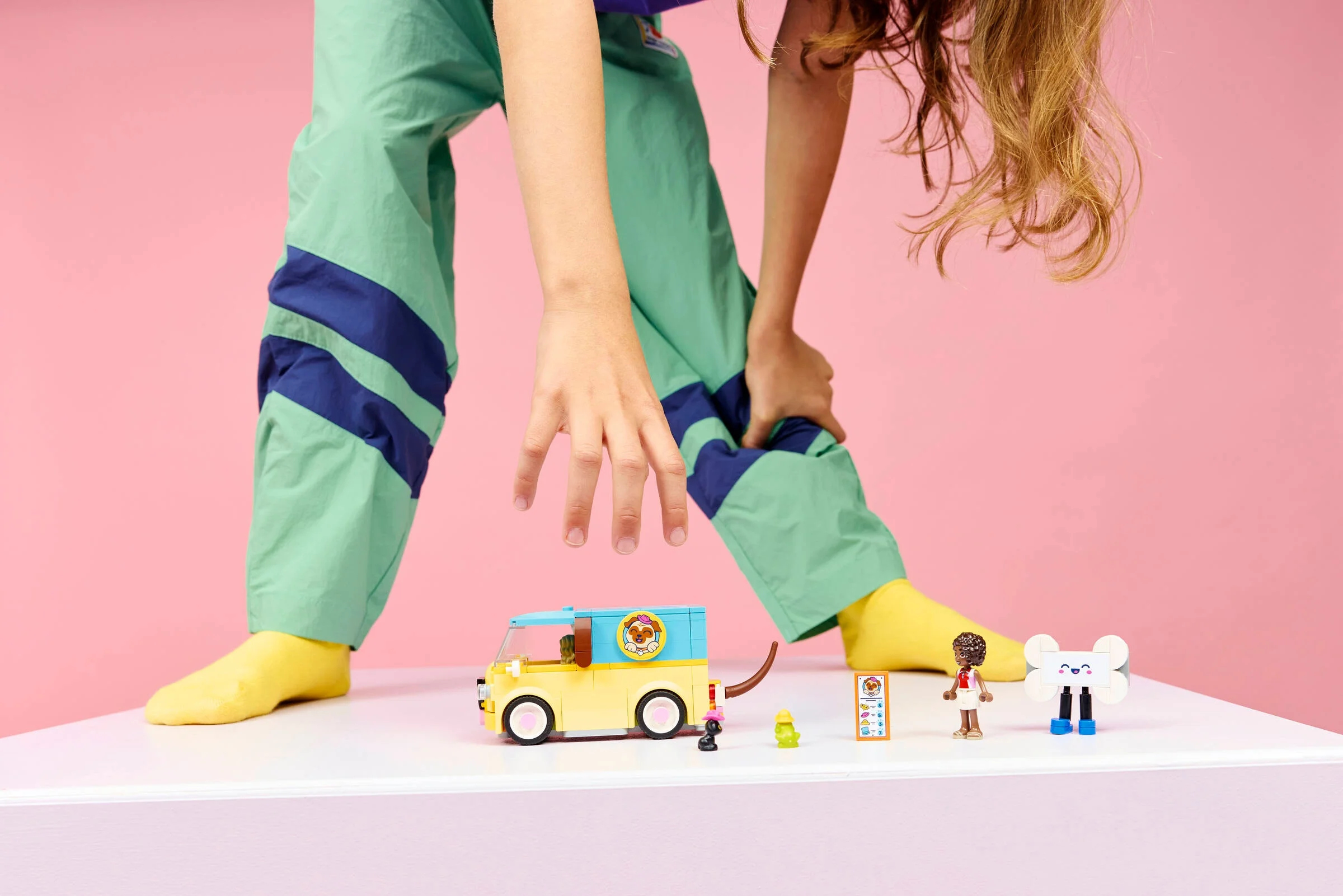 Vană de îngrijire animale LEGO Friends, cu accesorii și minifigurine pe fundal roz.