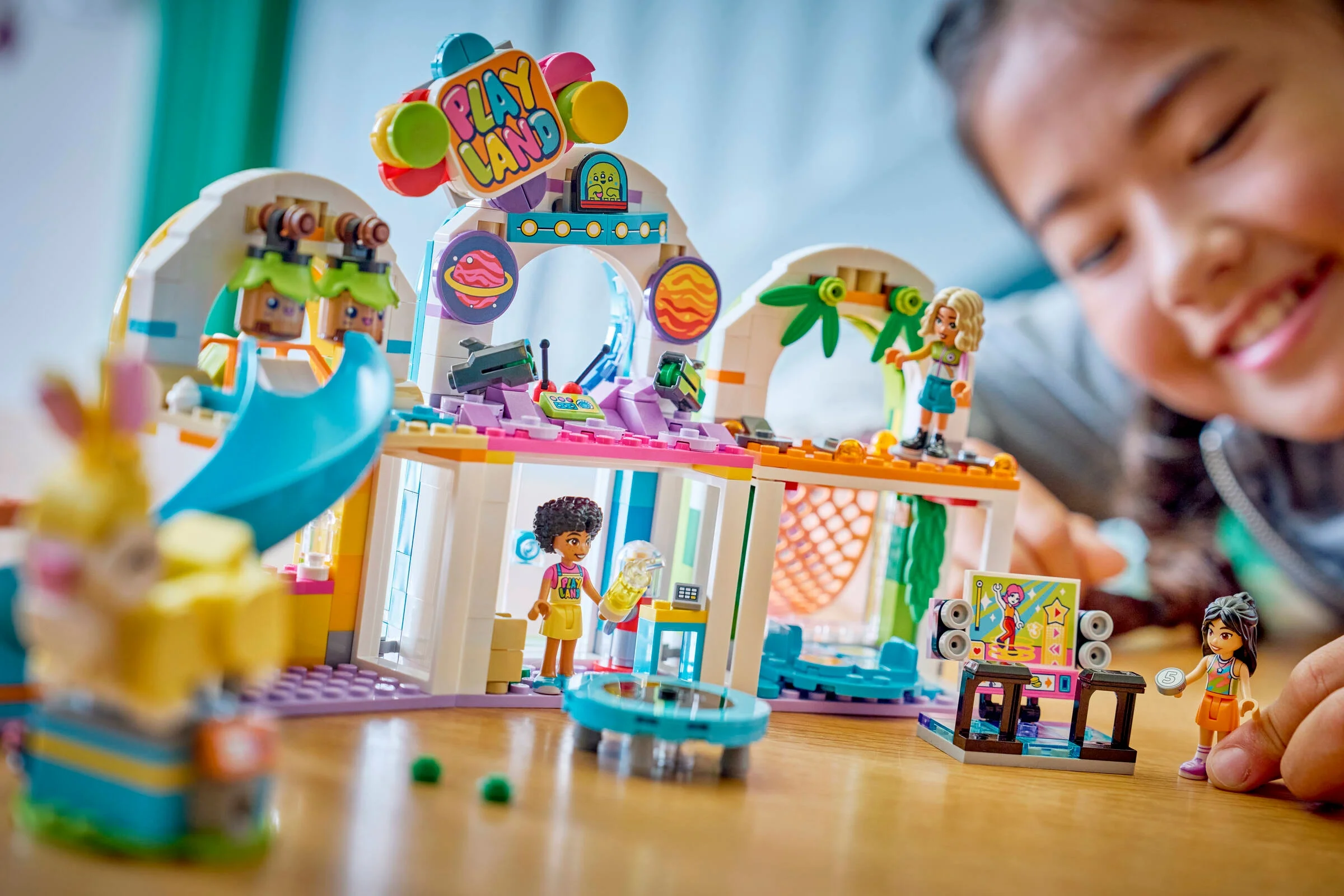 Imagine cu setul LEGO Friends 42686, prezentând un loc de joacă interior colorat și fetițe jucându-se.