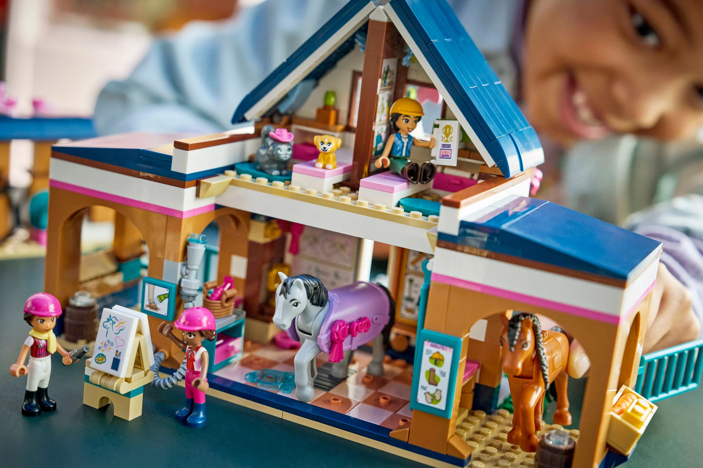 Imagine cu grajdul și academia de călărie LEGO Friends 42688. Vedere frontală, detaliată, plină de culoare.