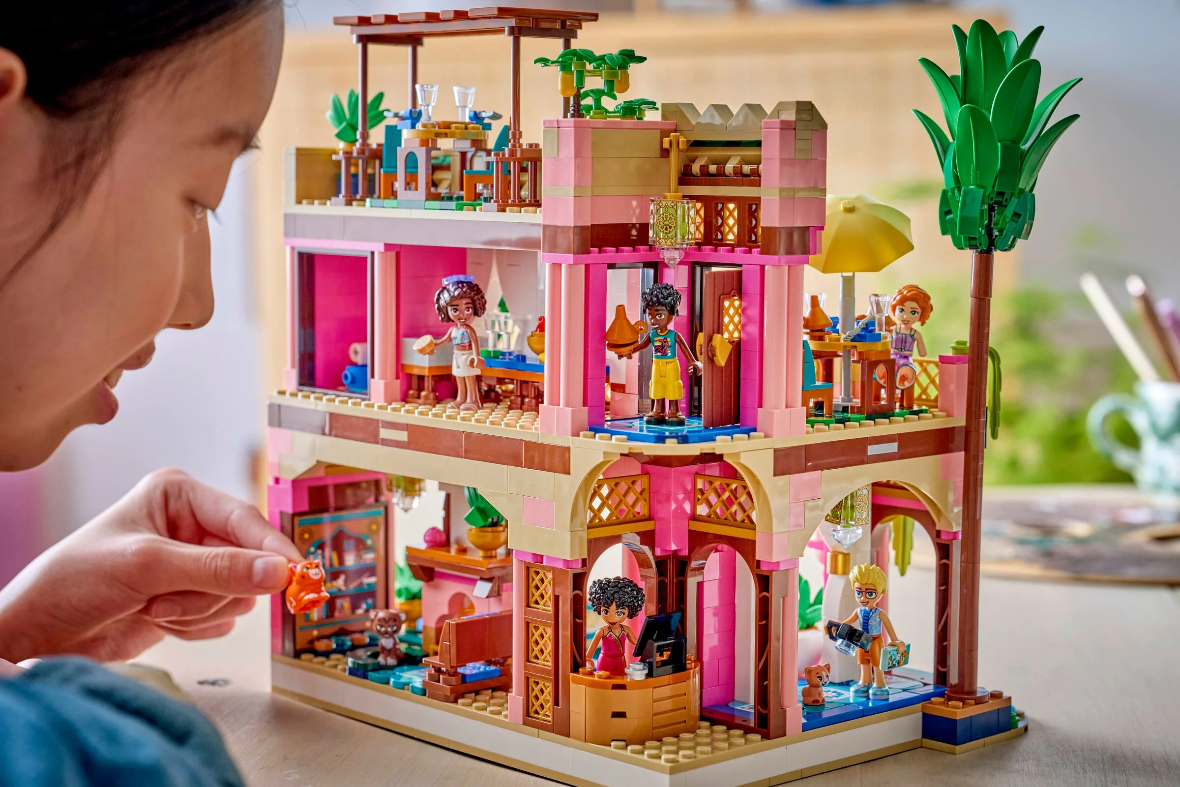 Imagine cu restaurantul LEGO Friends, parțial construit și cu o fată care adaugă o figurină mică.
