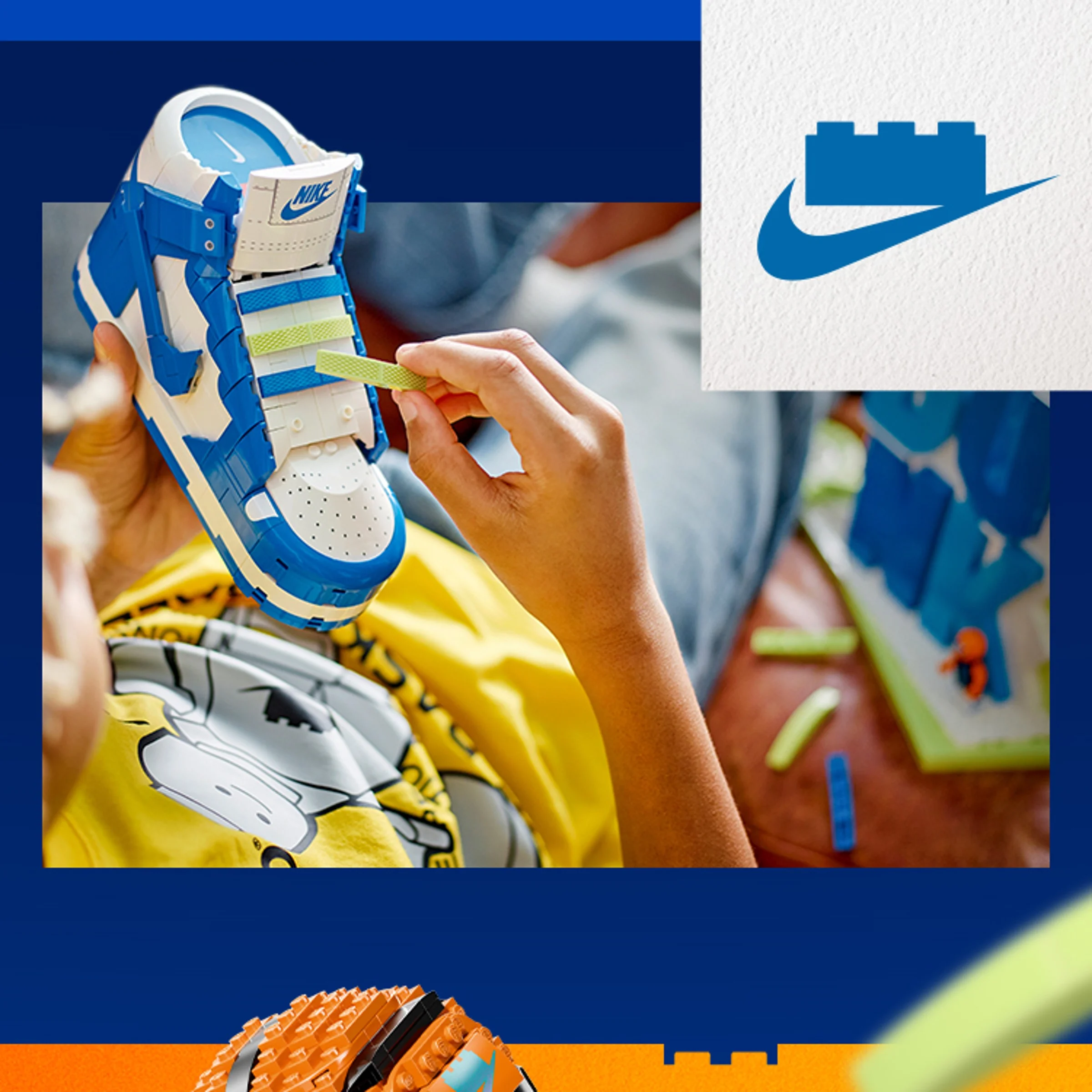 Mână adăugând detalii la pantoful Nike Dunk LEGO, alb și albastru.