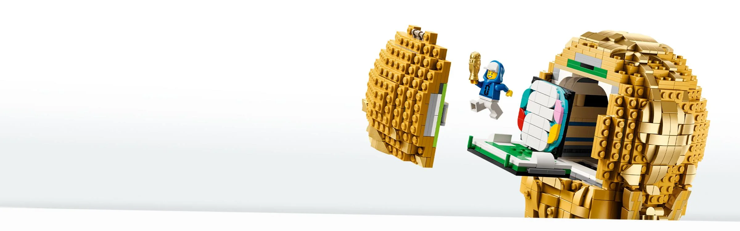 Trofeul FIFA din cărămizi LEGO deschis, cu minifigurina sărbătorind.