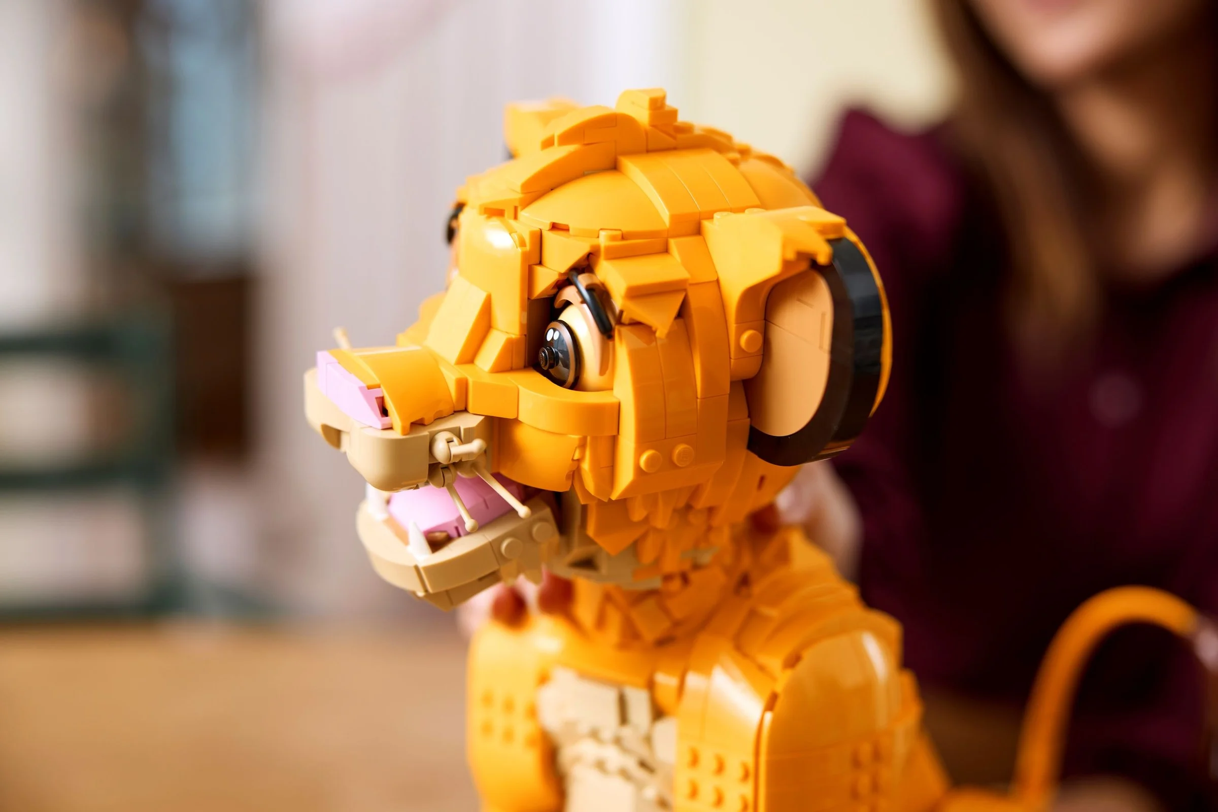 Prim-plan cu Simba tânăr din LEGO, detaliat. Personaj Disney construit din cărămizi galbene.