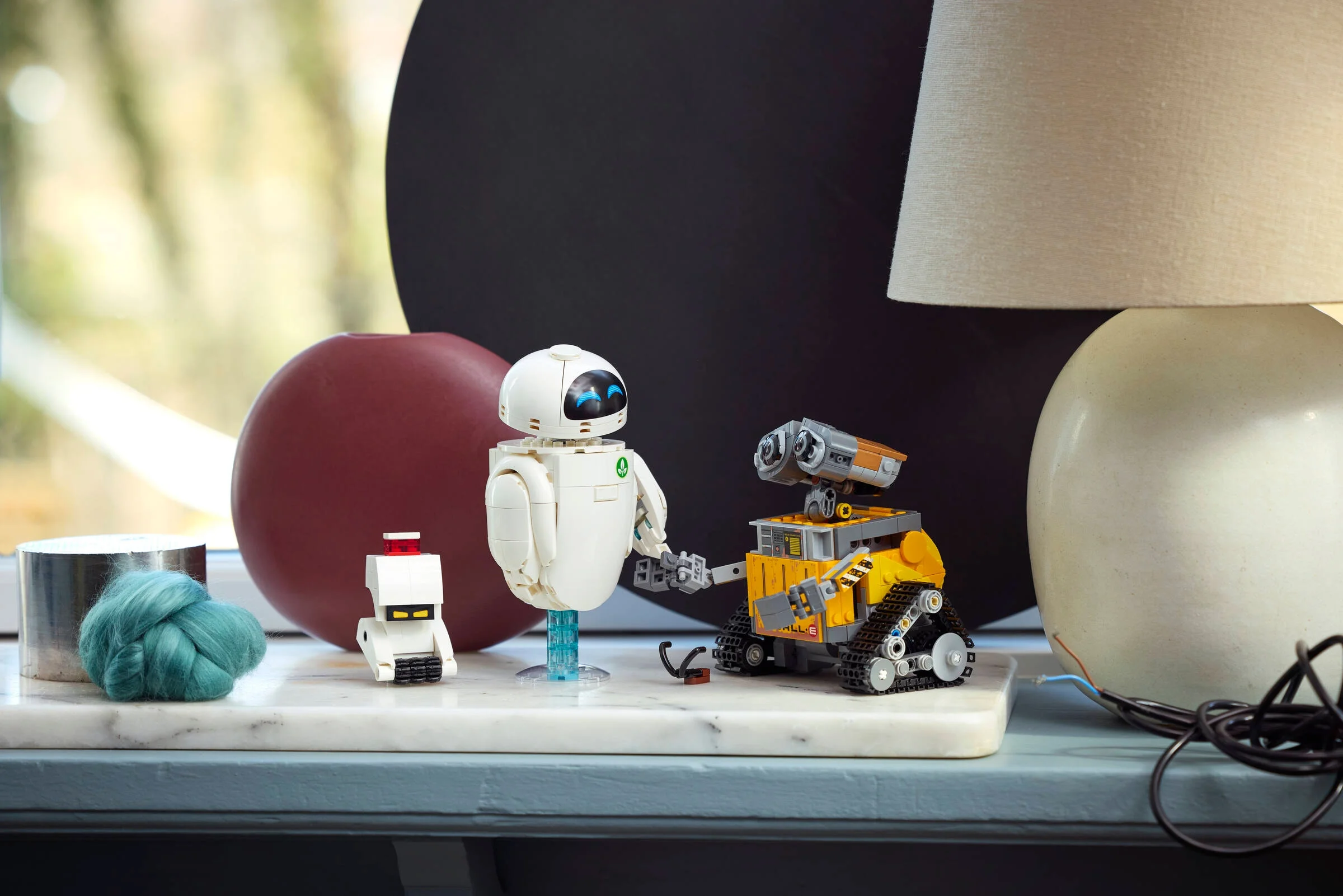 Imagine cu WALL-E și EVE LEGO (43279), roboții prietenoși într-un cadru decorativ.