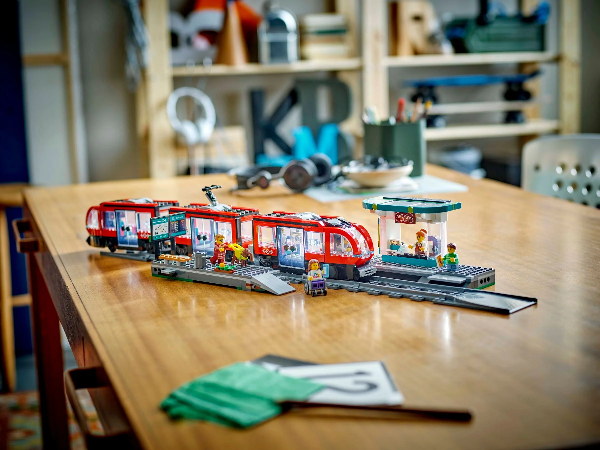 Tramvaiul urban LEGO City 60423 cu peroane și minifigurine pe o masă.