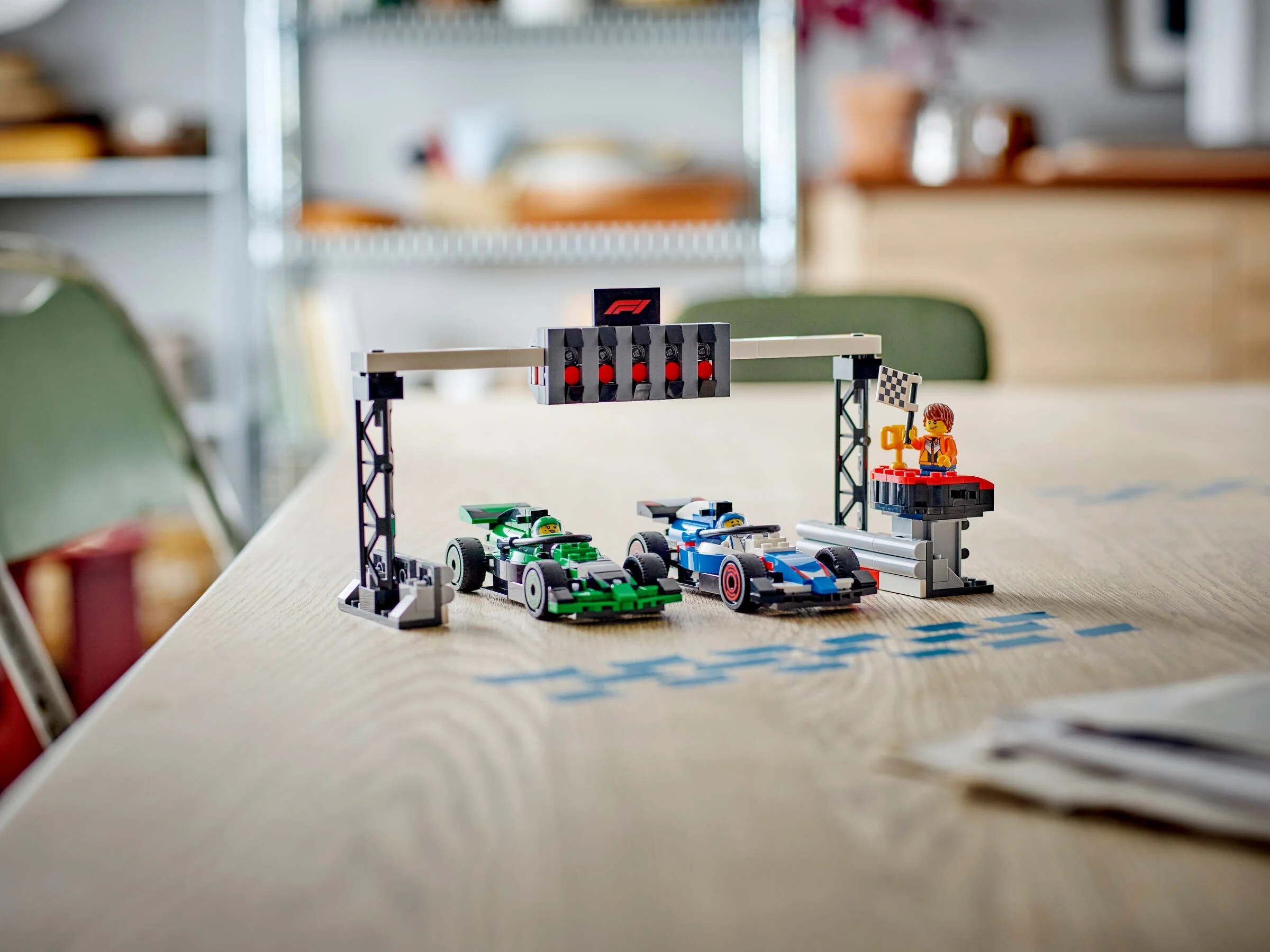Două mașini de curse F1 LEGO, Sauber și VCARB, la linia de start/finiș.