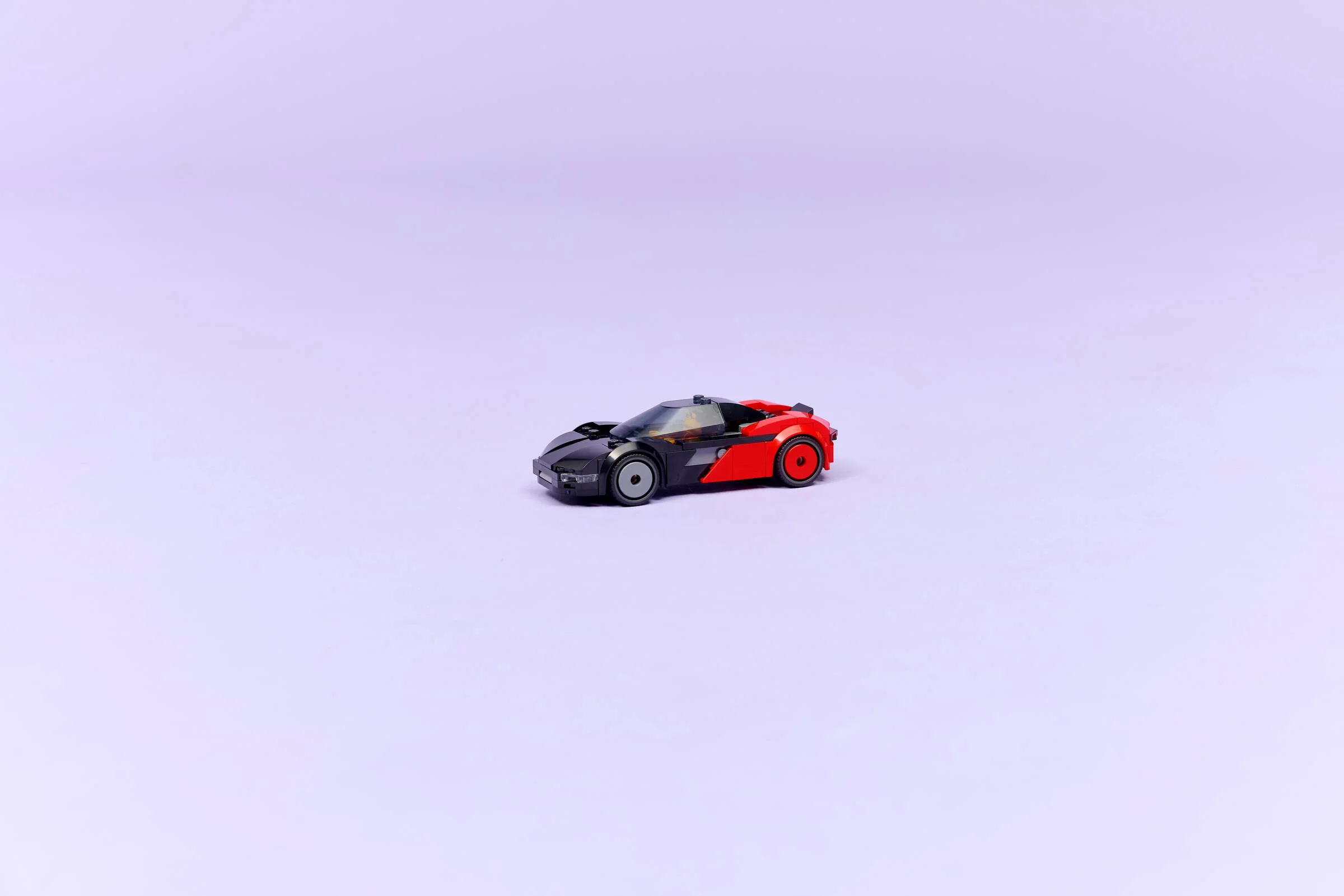 Supercar electric LEGO City 60486, negru și roșu, pe fundal violet pal.