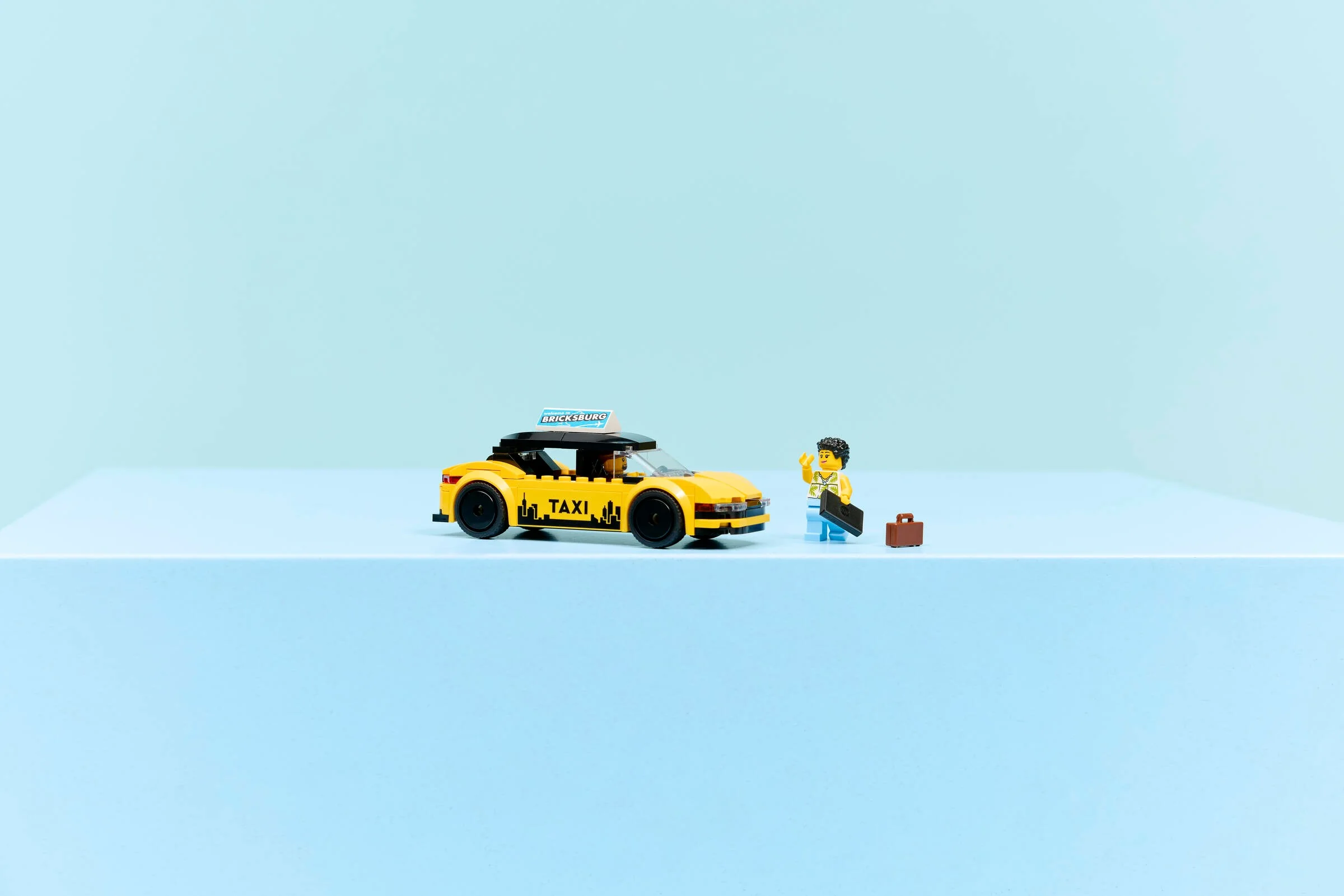Imagine cu taxiul galben LEGO City 60487 și o minifigurină cu valiză.