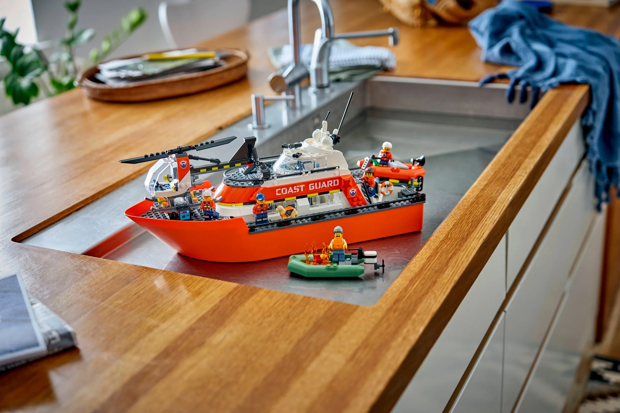 Barca de salvare LEGO Coast Guard și accesorii, aranjate pe un blat de bucătărie.