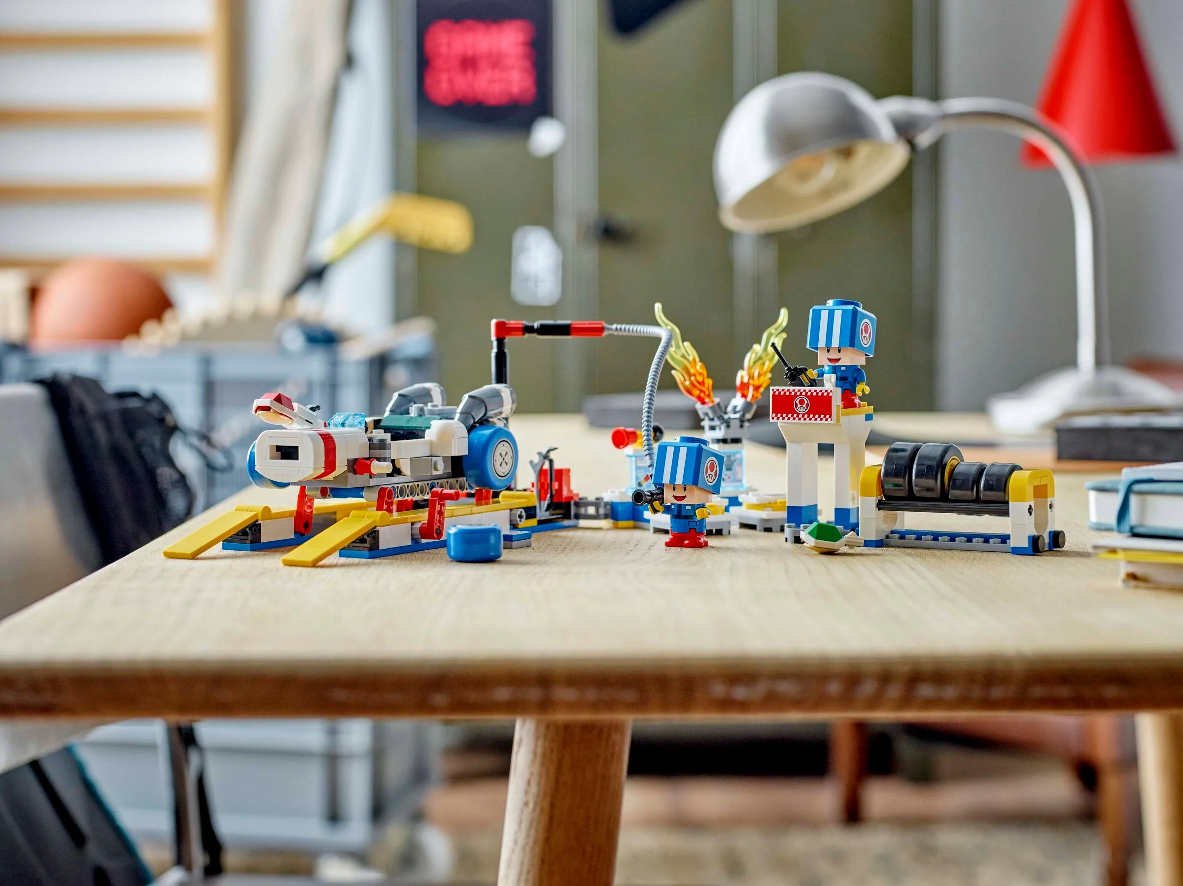 Setul LEGO Toad's Garage prezentat complet, cu minifigurine și mașină, pe o masă.