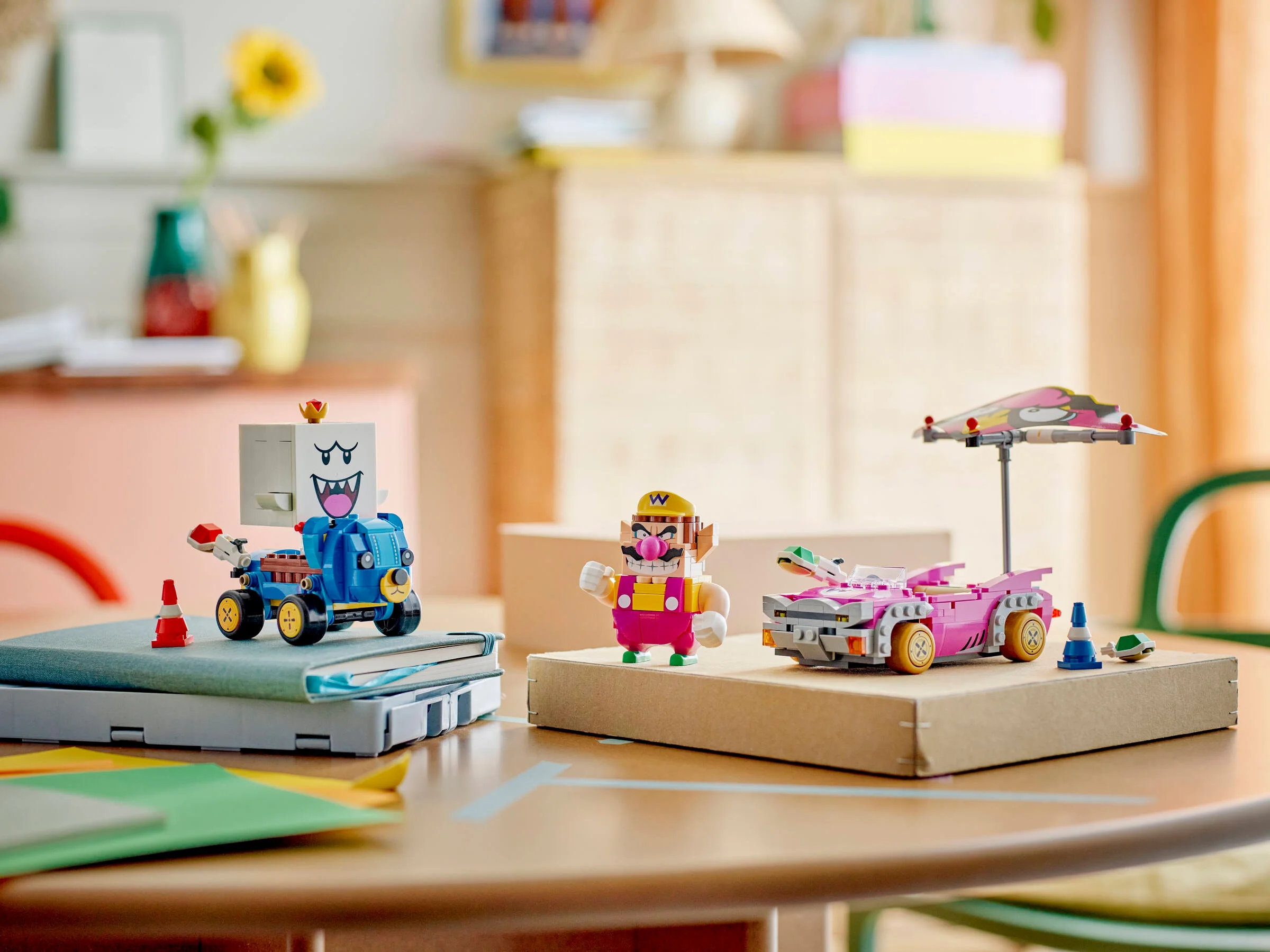 Wario și King Boo LEGO pe o masă, prezentând setul 72038. Imagine jucăușă, colorată.
