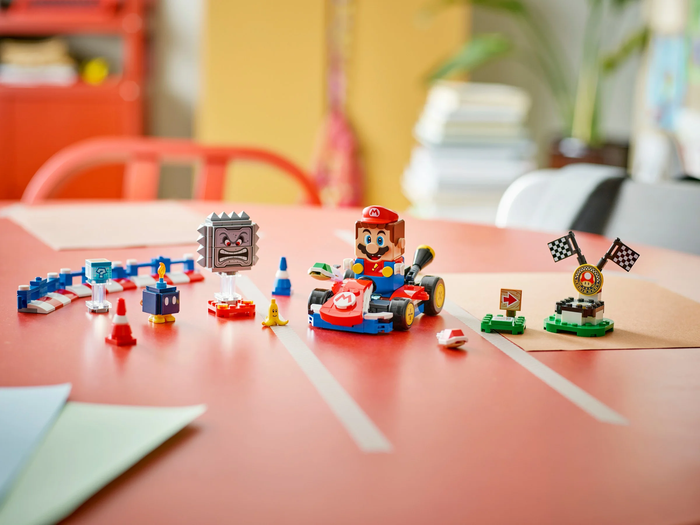 Imagine cu setul LEGO Mario și kartul său, alături de alte elemente interactive.