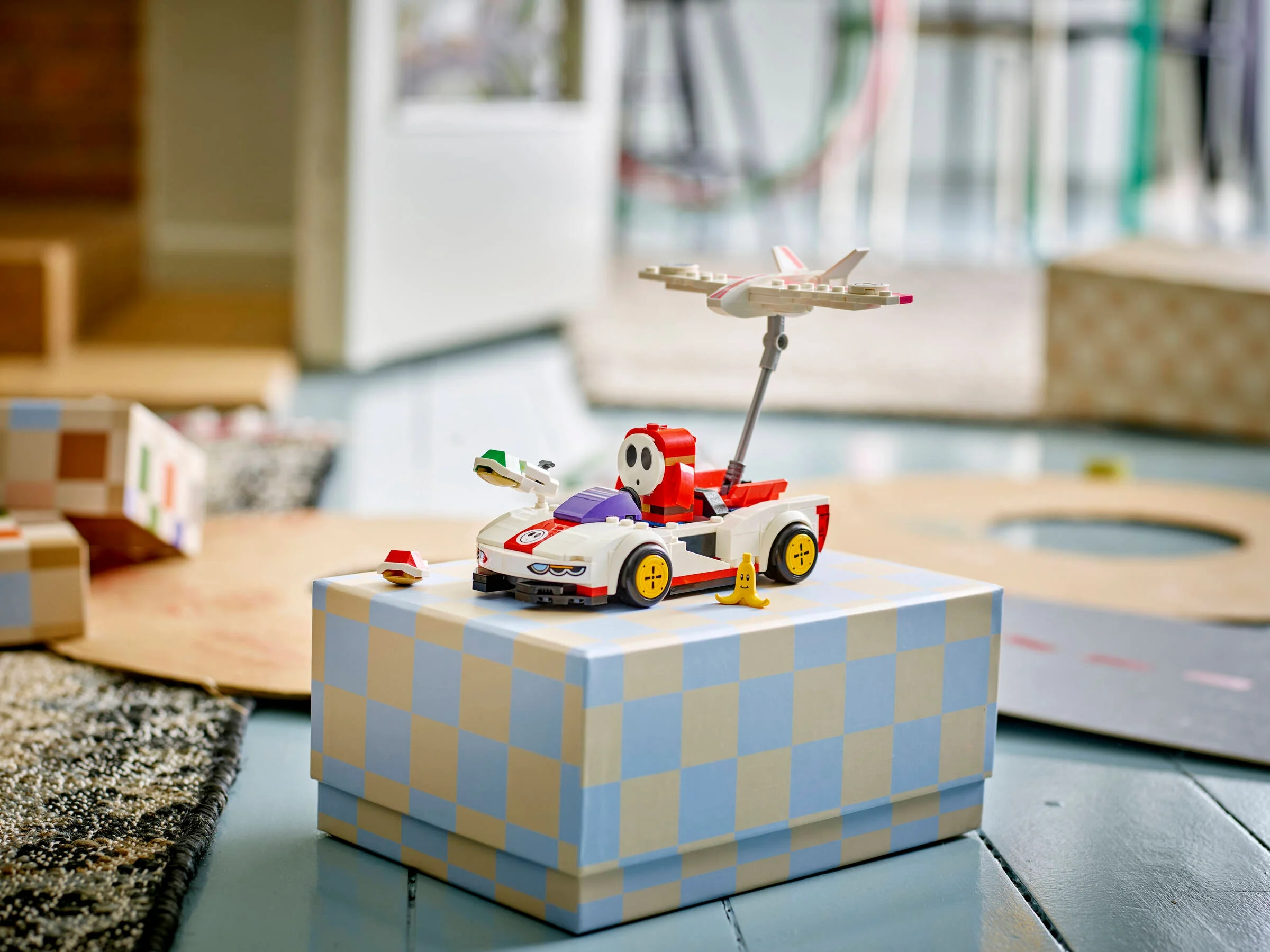 Imagine cu setul LEGO 72045 Shy Guy și P-Wing. Modelul este așezat pe o cutie.