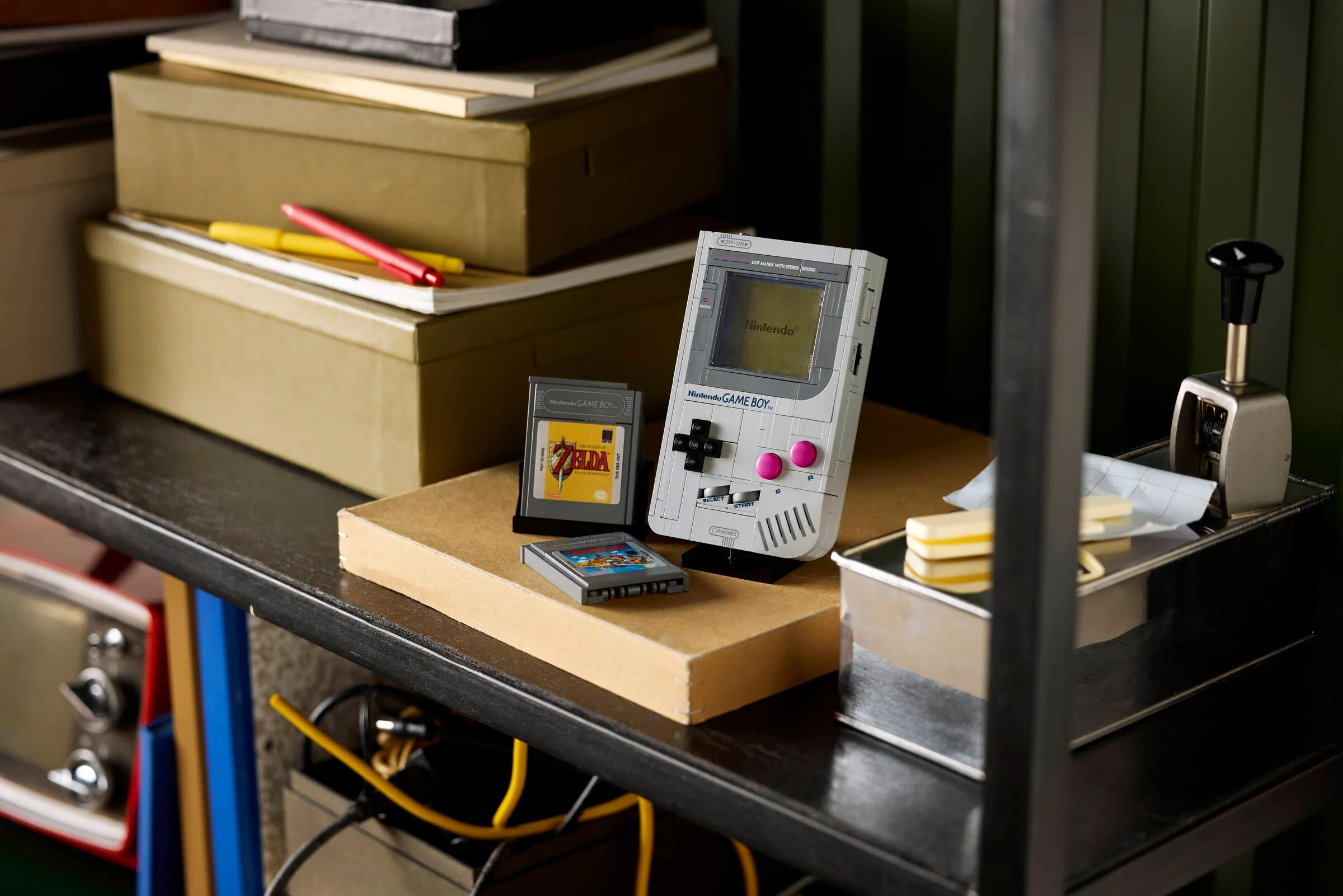 Imagine detaliată a modelului LEGO Game Boy, cu cartușe de joc și accesorii. O piesă nostalgică!