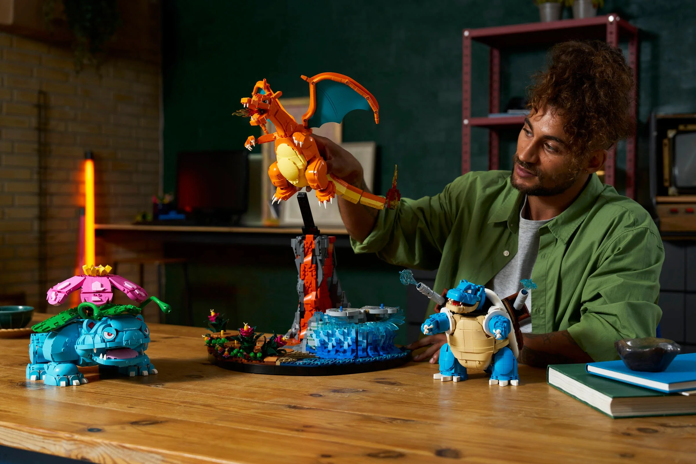 Imagine cu setul LEGO Pokémon Venusaur, Charizard și Blastoise, afișat pe o masă de lemn.