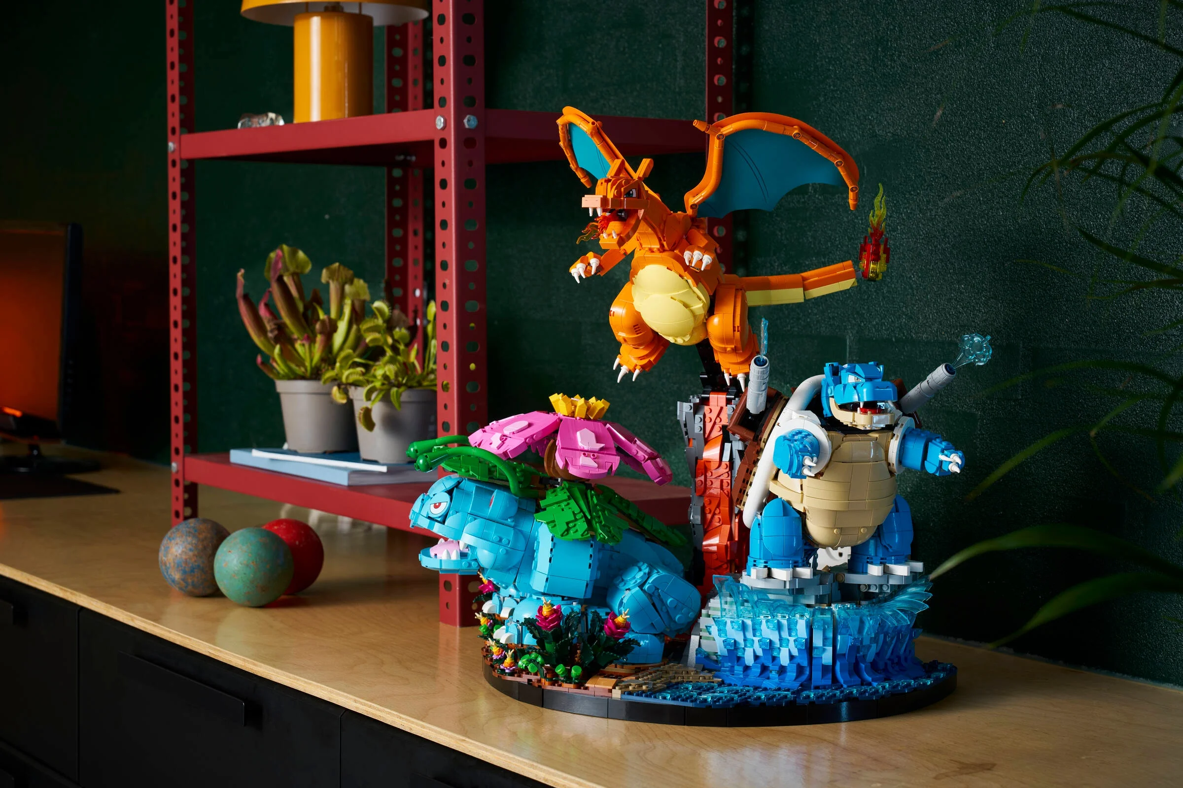 Imagine cu setul LEGO Venusaur, Charizard și Blastoise, pe un raft, aranjat ca o dioramă.