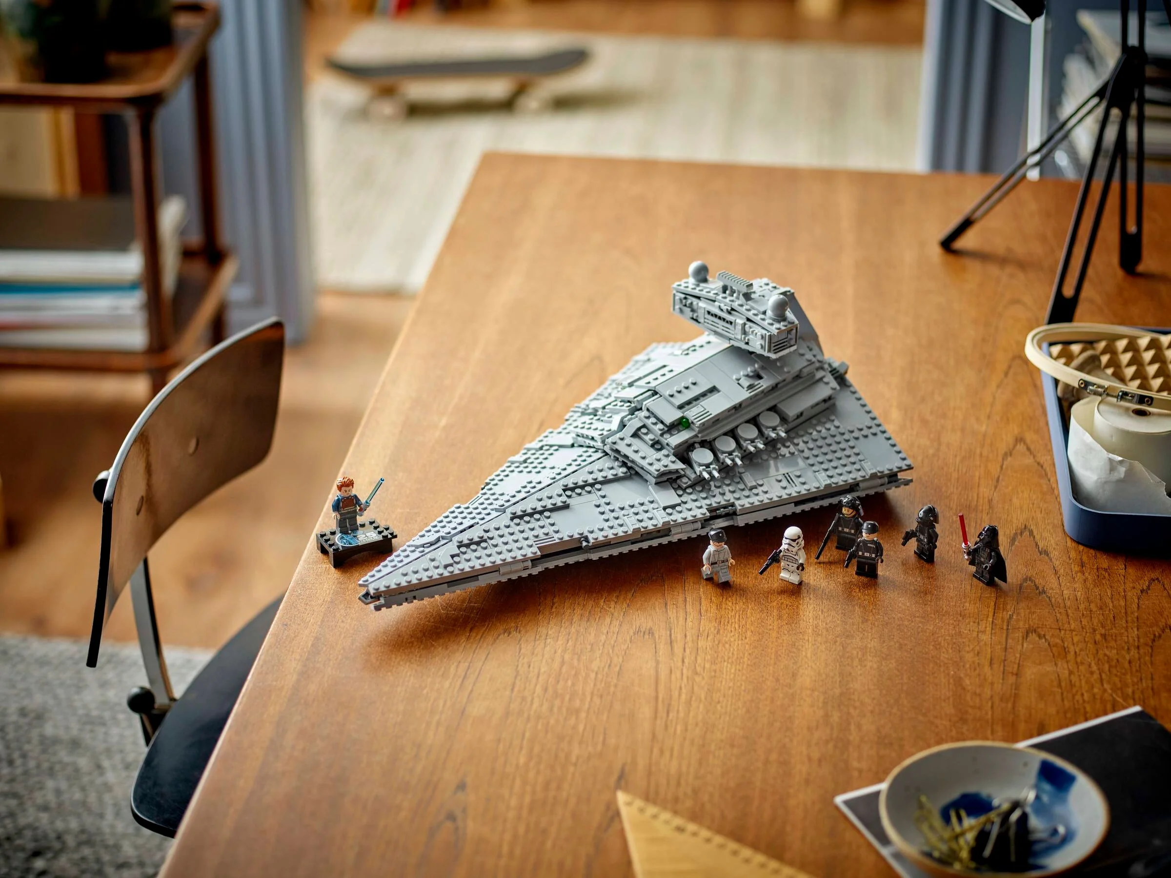 Imagine cu modelul Star Destroyer și minifigurinele asociate pe o masă de lemn.