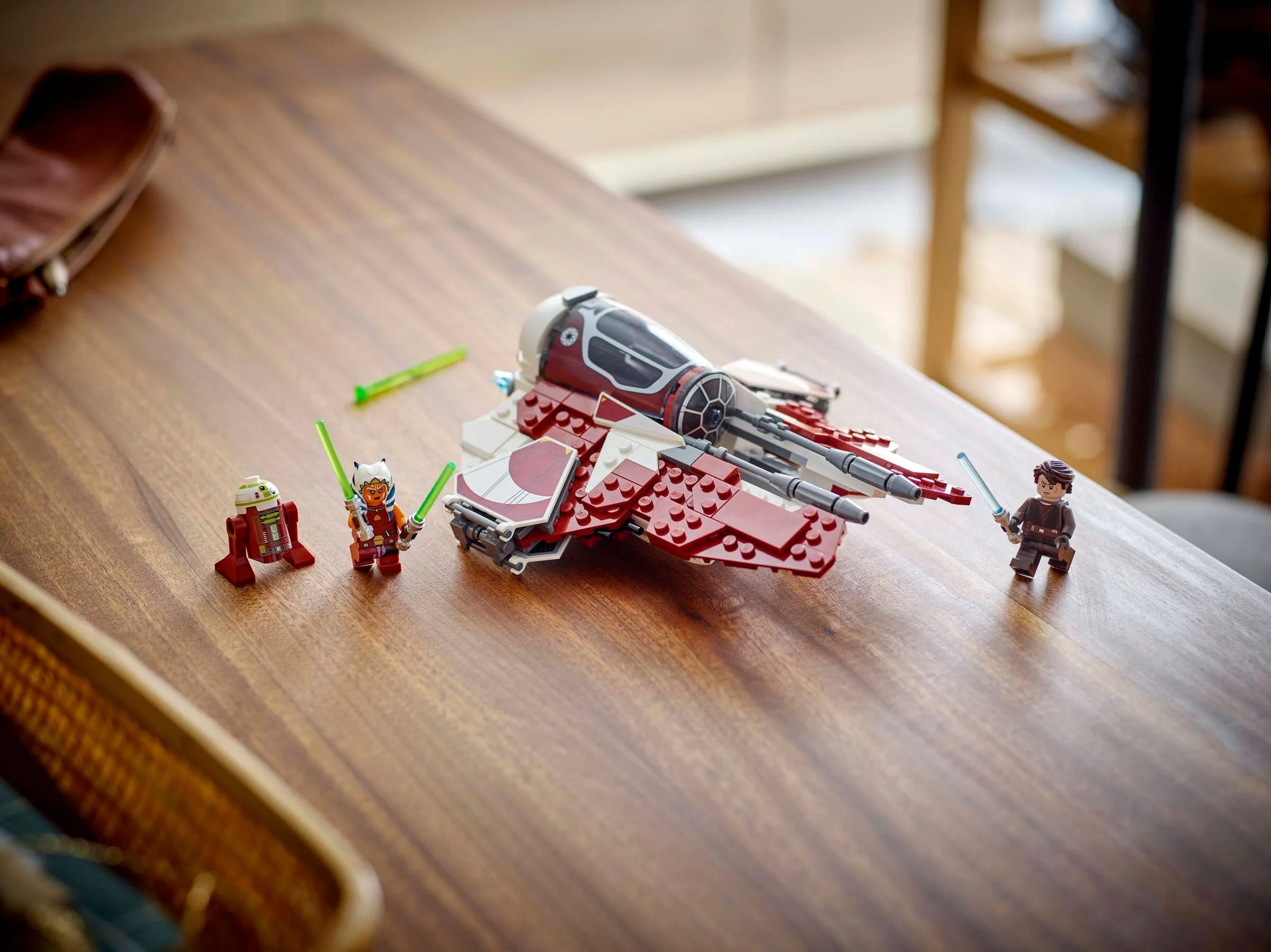 Ahsoka's Jedi Interceptor LEGO 75401 și minifigurinele pe o masă de lemn.