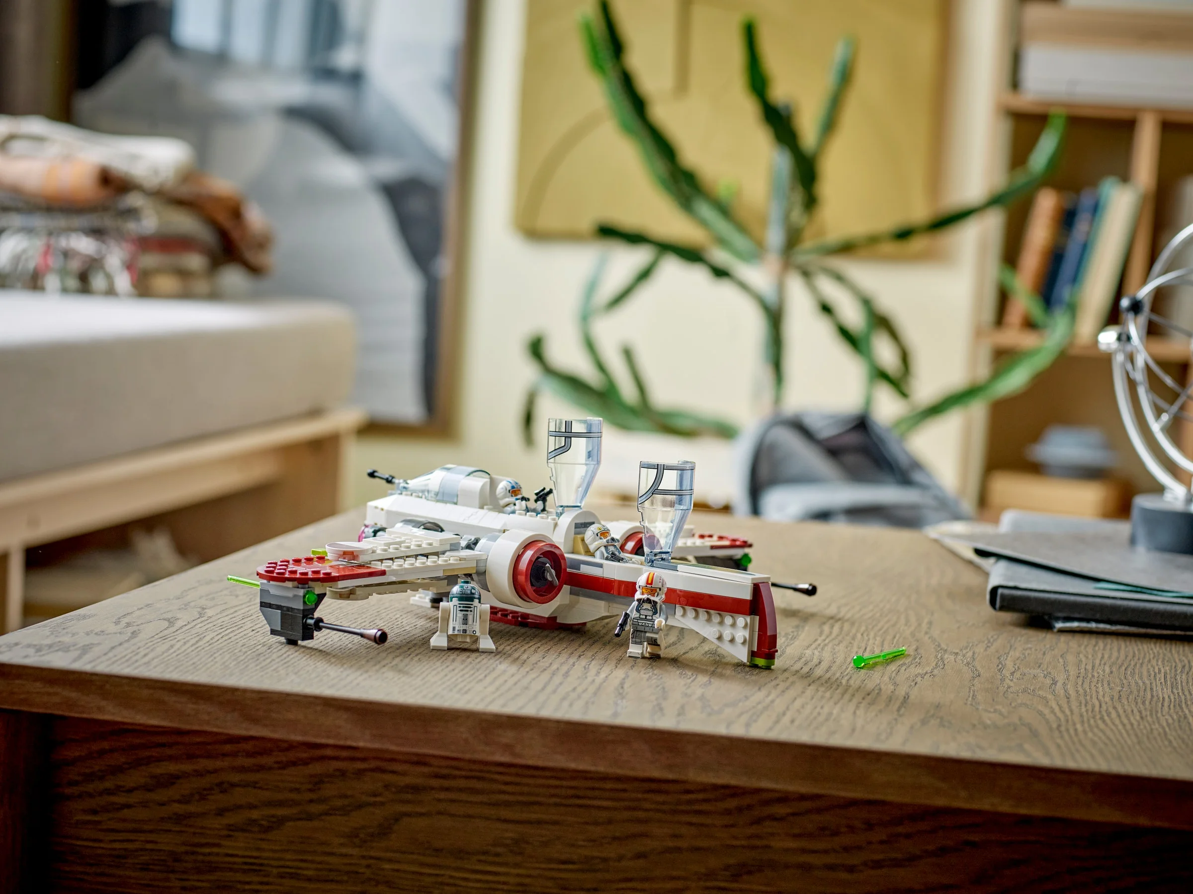 Imagine cu modelul finalizat ARC-170 Starfighter și minifigurinele incluse pe o masă.