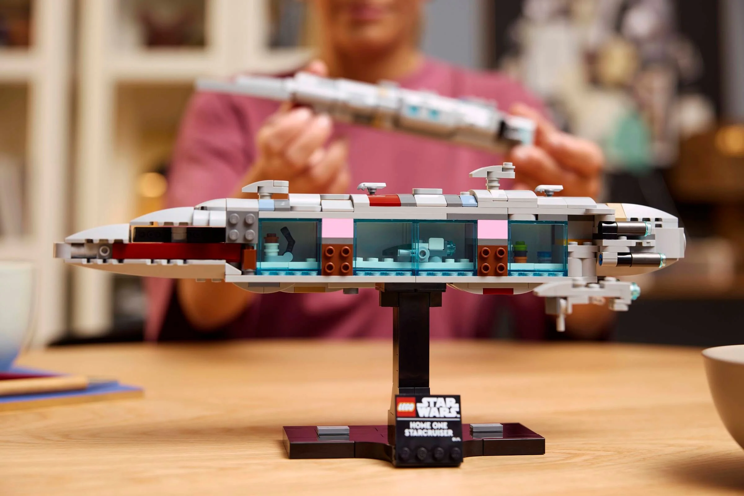 Modelul LEGO Home One Starcruiser 75405, detaliat, pe suport. Interior vizibil.
