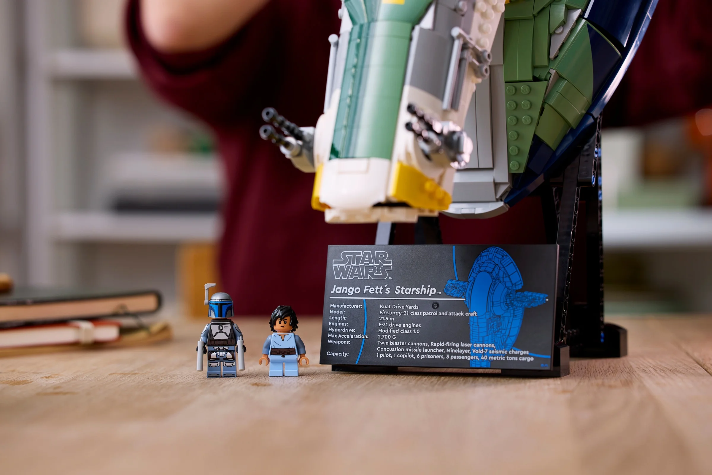 Modelul Starship al lui Jango Fett, cu minifigurine și panou informativ. Arată complexitatea designului.