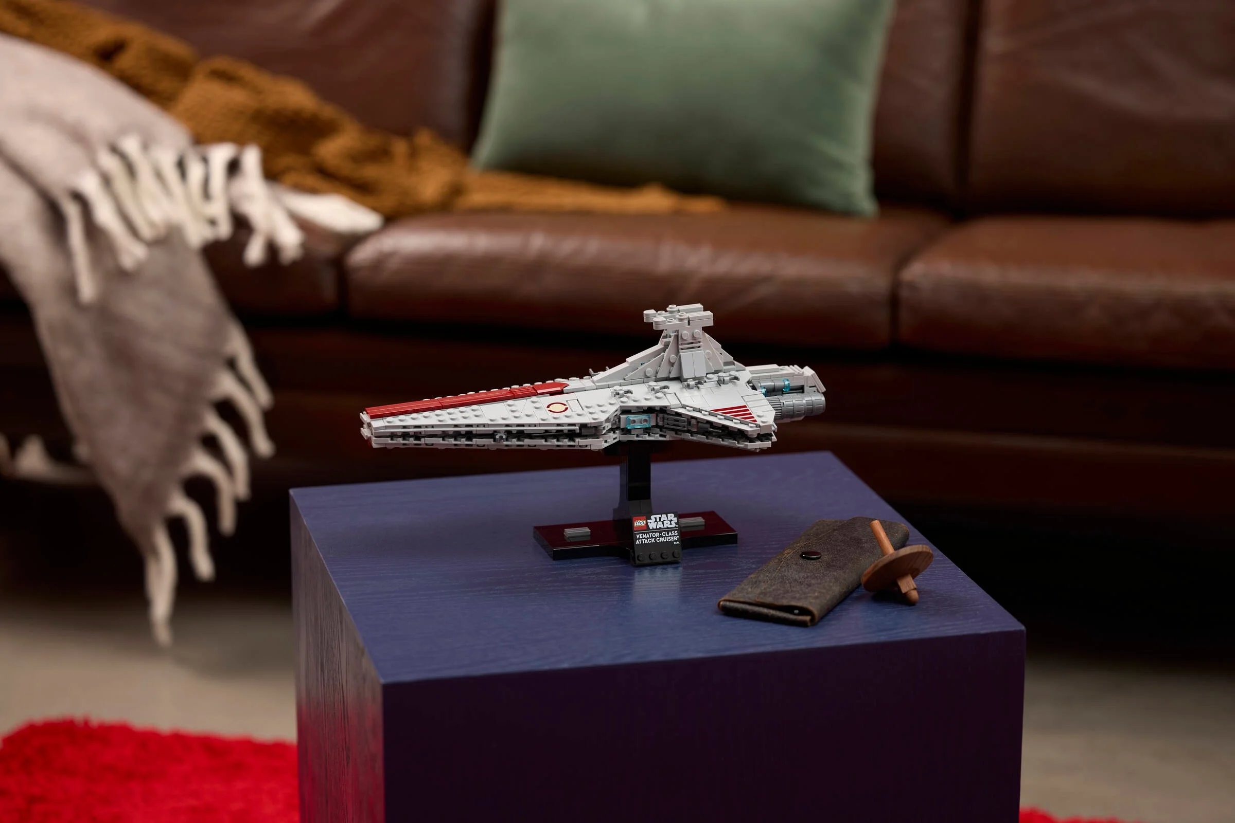 Vedere a modelului Venator-class Attack Cruiser, expus pe suport. Model detaliat, gri cu roșu.