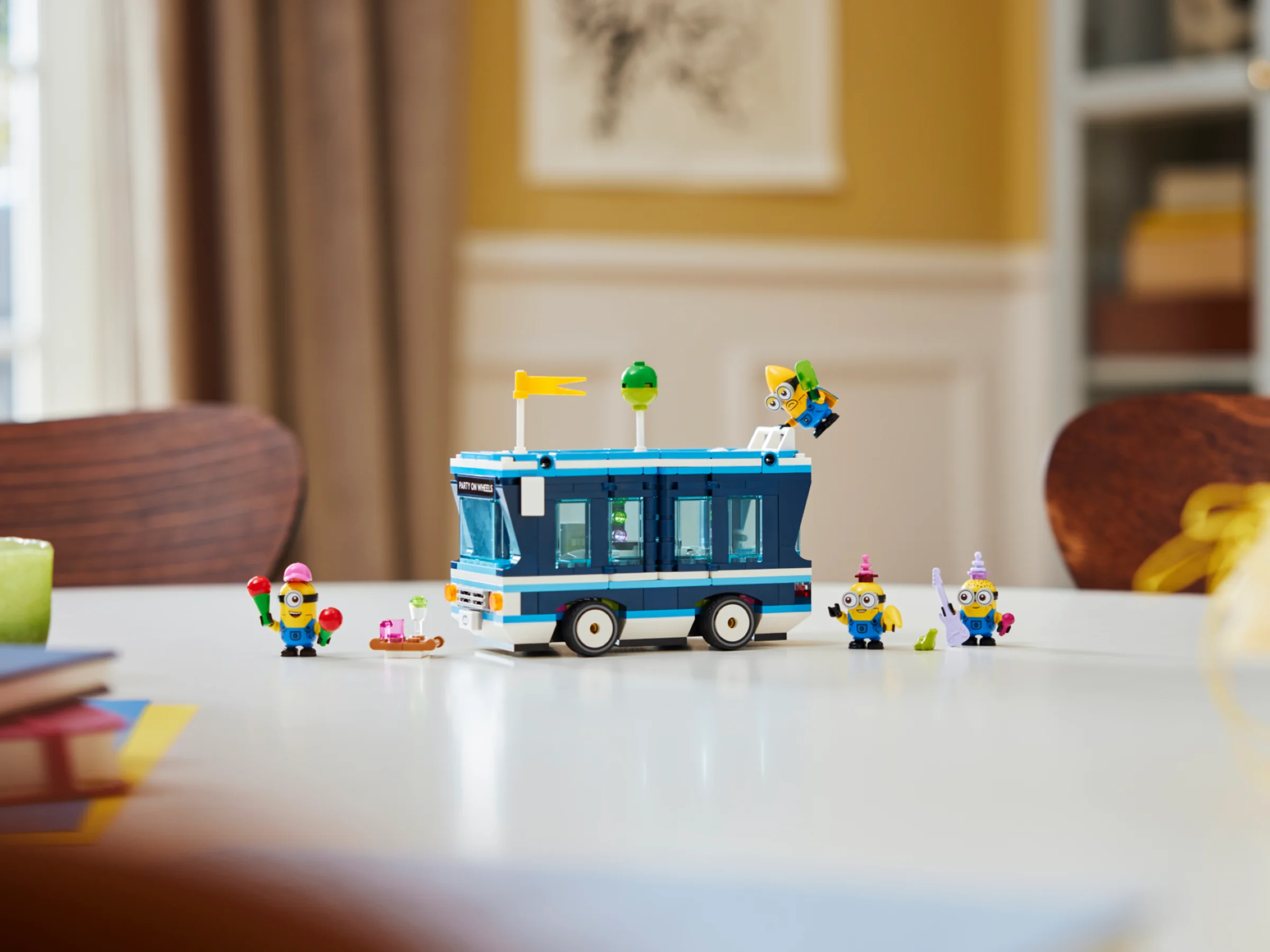 Imagine cu autobuzul muzical LEGO Minions și minifigurinele aferente, aranjate pe o masă.