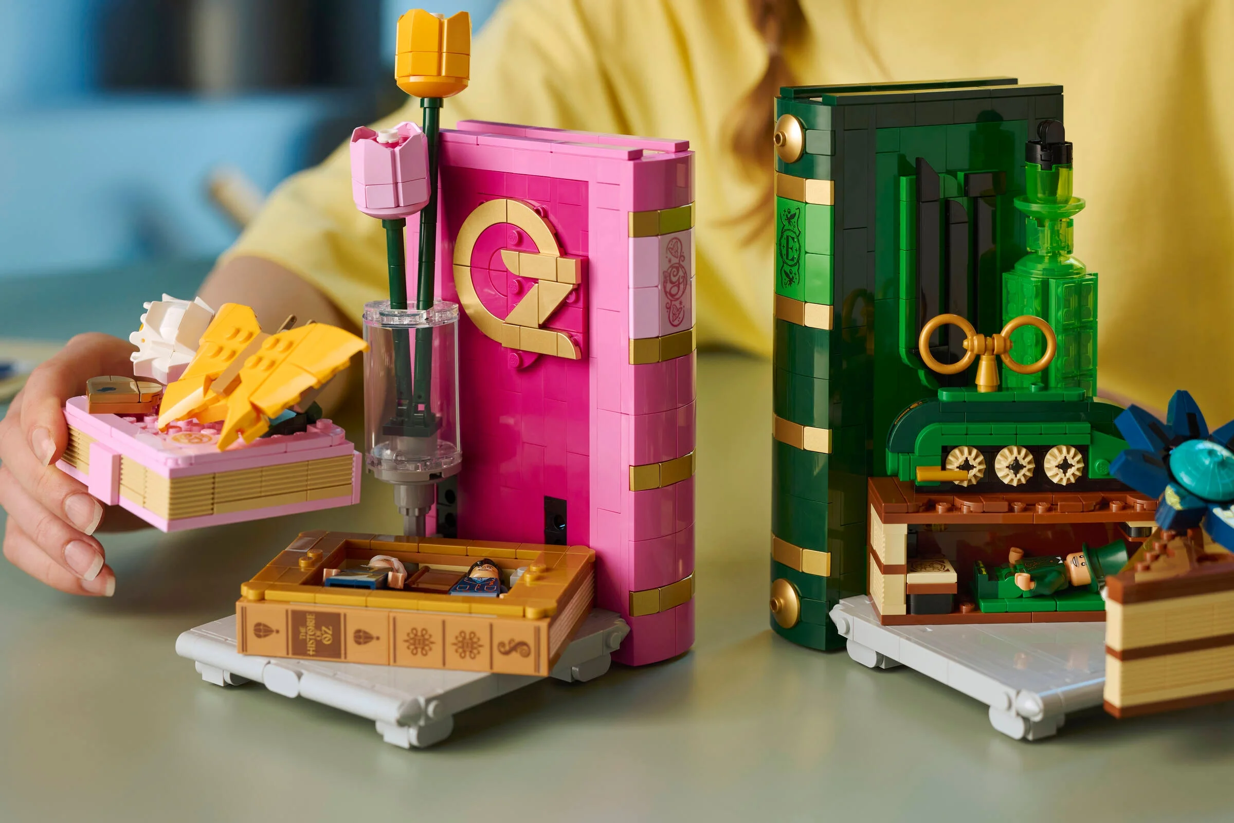 Setul LEGO 75691 include statuete cu Glinda și Elphaba, integrat într-un design de suporturi de cărți.
