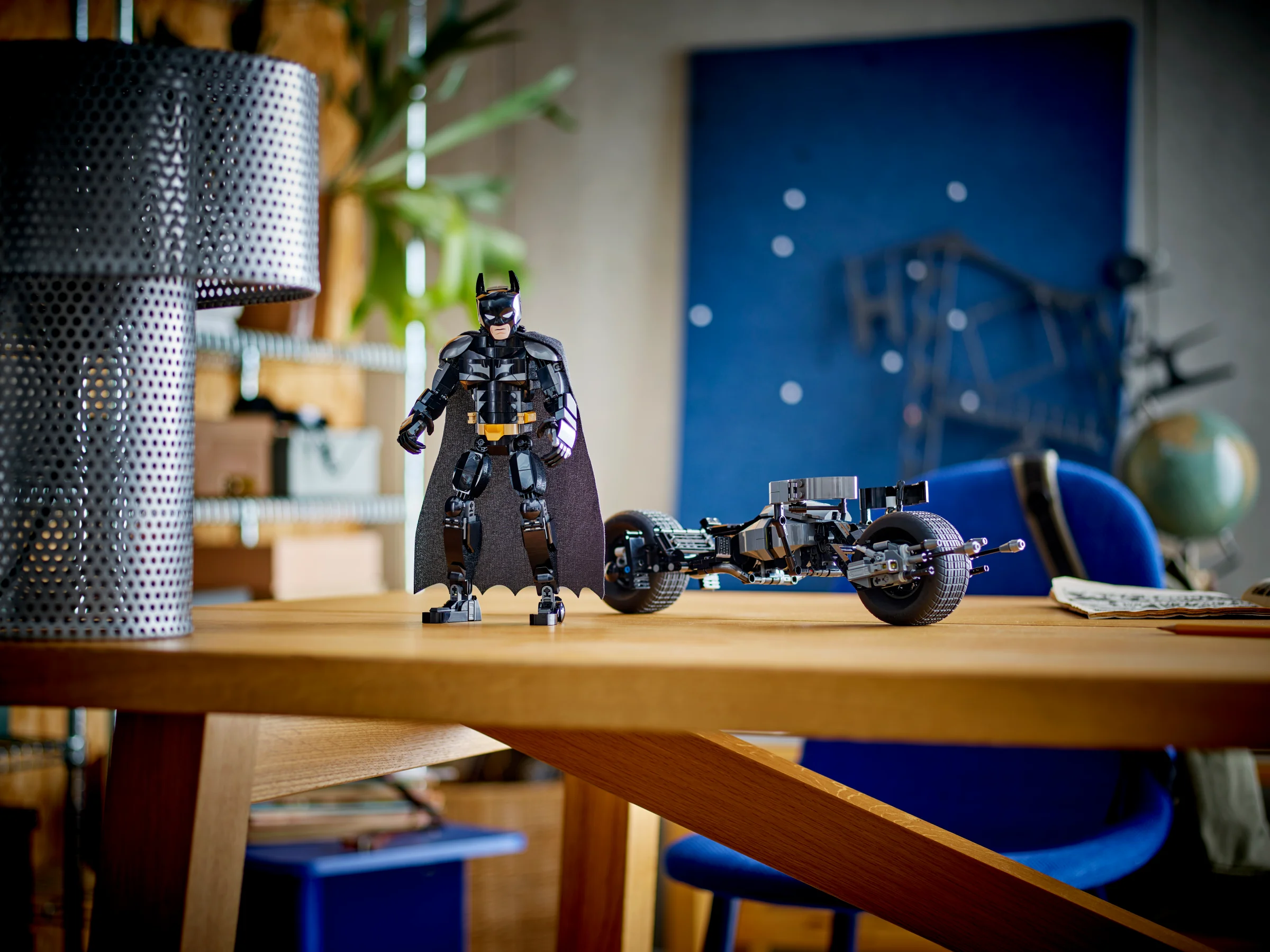 Figurină Batman construibilă și motocicleta Bat-Pod, prezentate pe un birou. Detalii vizibile.