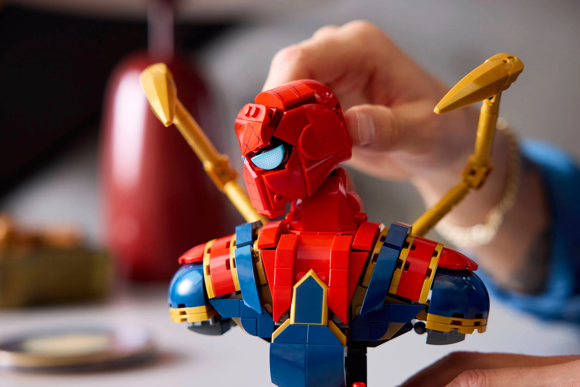 Prim plan al bustului Iron Spider-Man LEGO, detaliind culorile și designul.