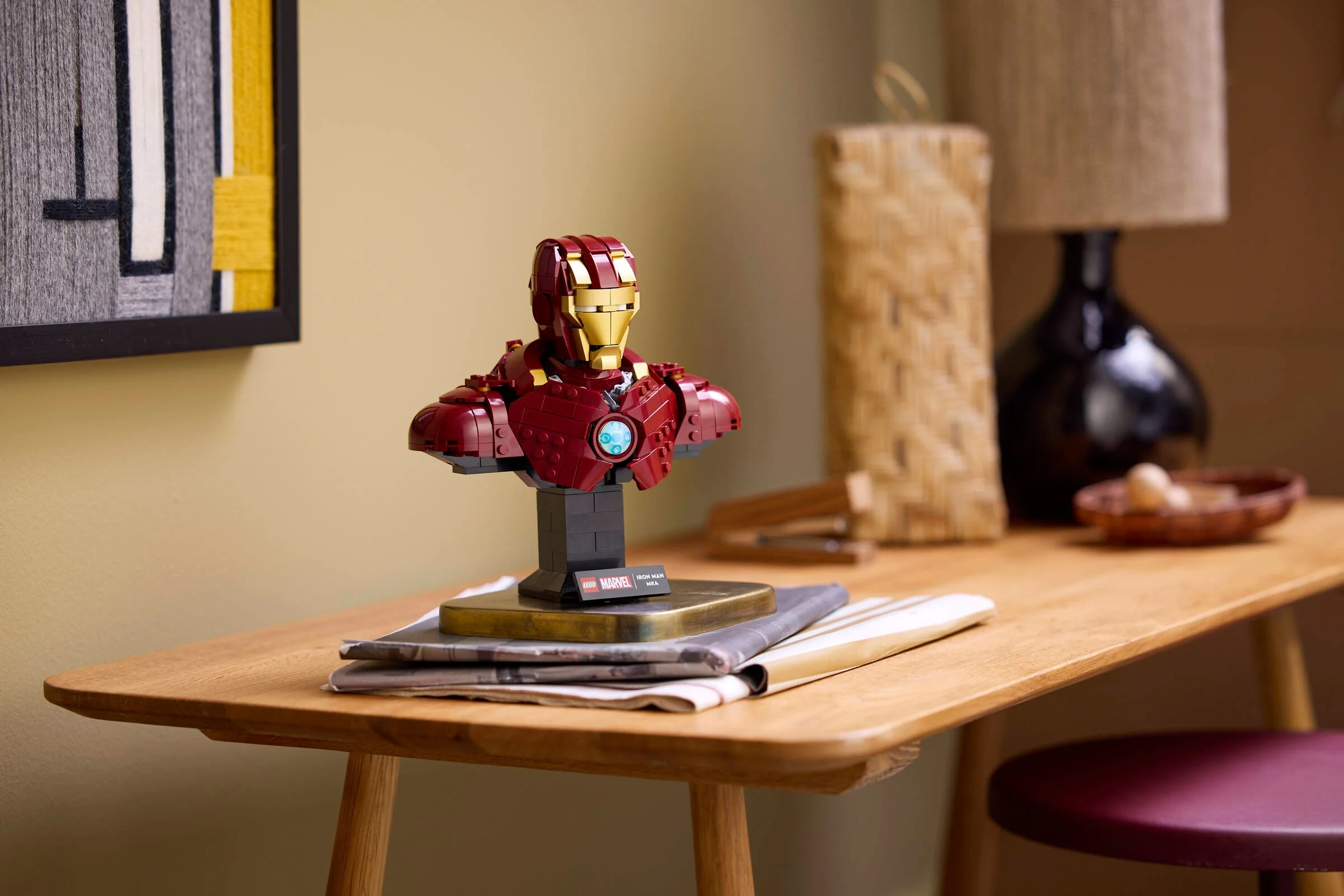 Prim-plan bust Iron Man MK4 pe o masă, cu detalii ale designului și culorilor.