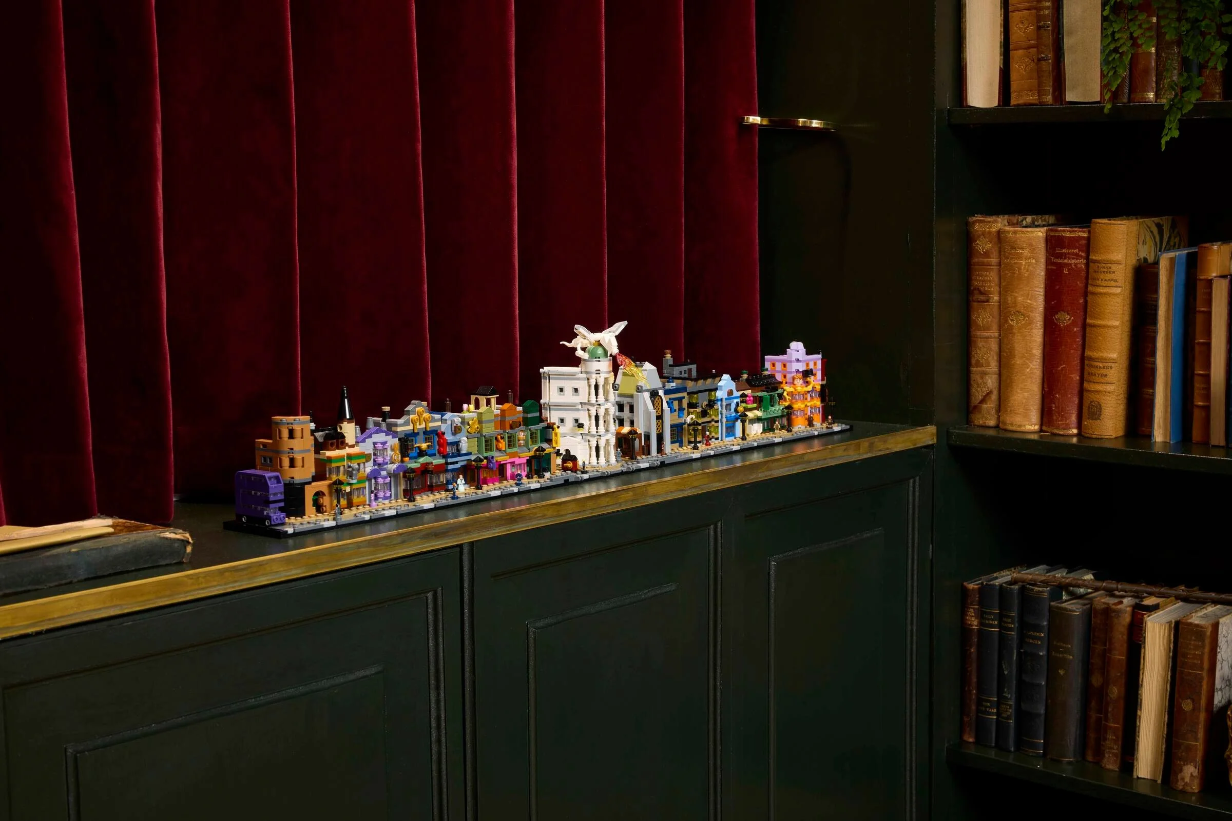 O imagine cu setul LEGO Diagon Alley Wizarding Shops (76444) pe un raft, într-un cadru amenajat.