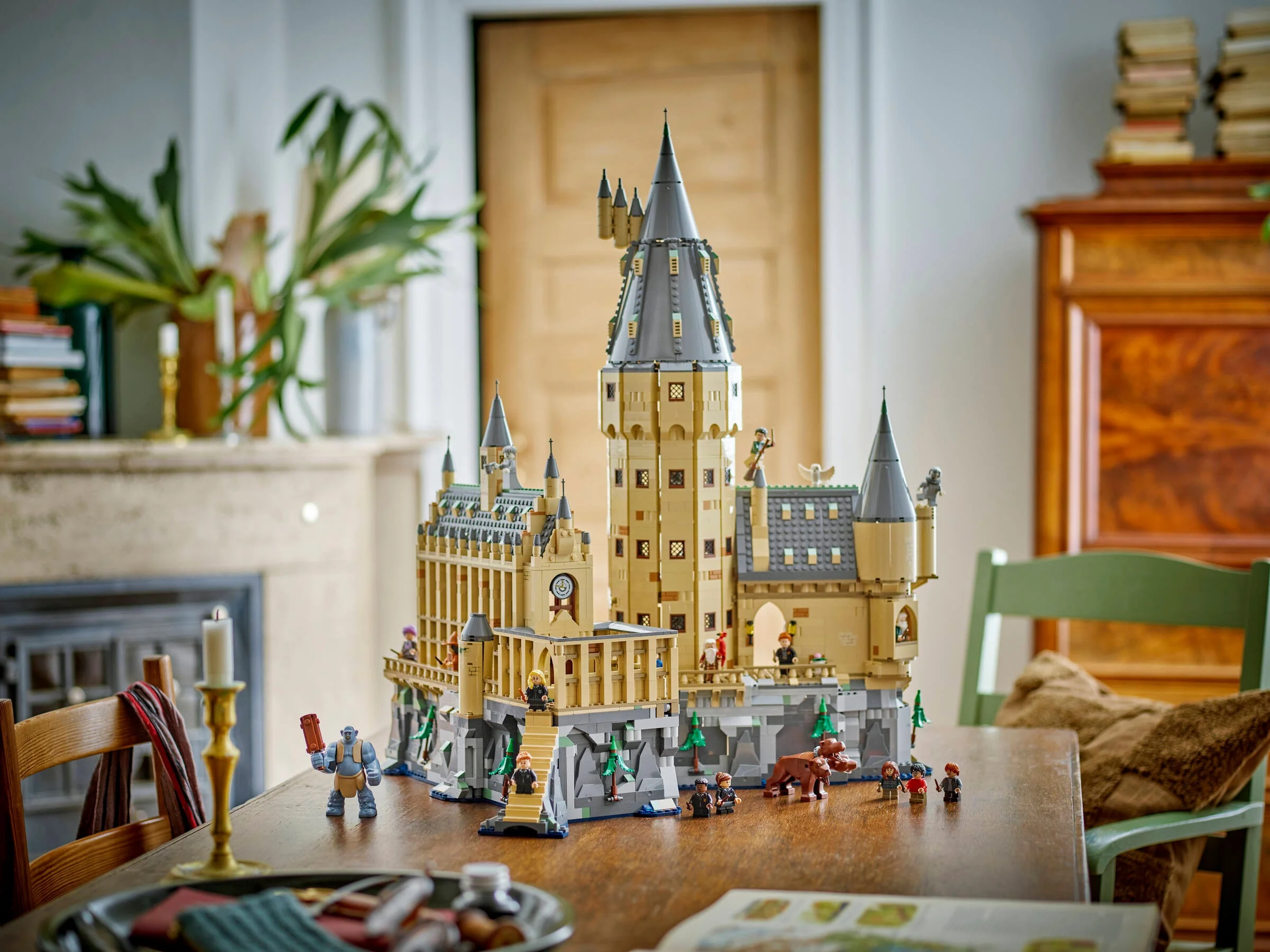 O imagine a castelului Hogwarts LEGO, setul 76454, cu minifigurinele incluse, așezat pe o masă.