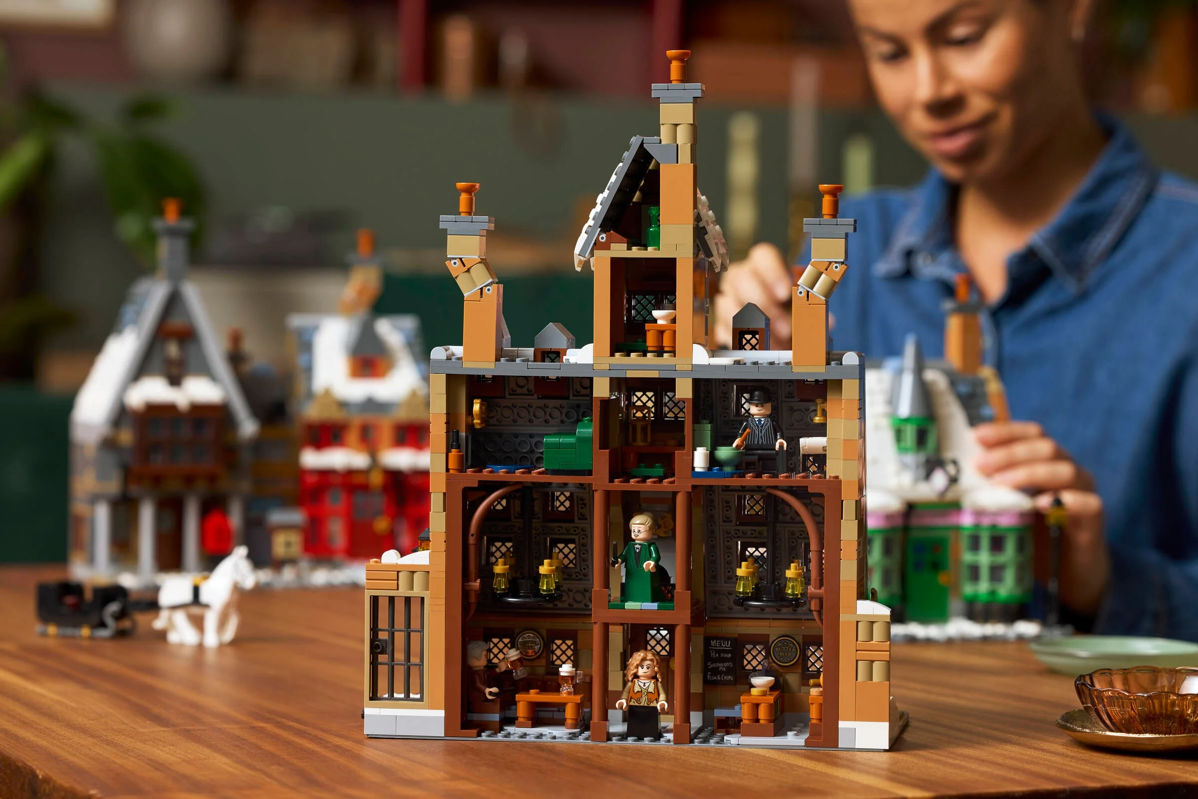 Modelul LEGO Hogsmeade cu minifigurine și detalii ale clădirilor. Aspect detaliat al setului.