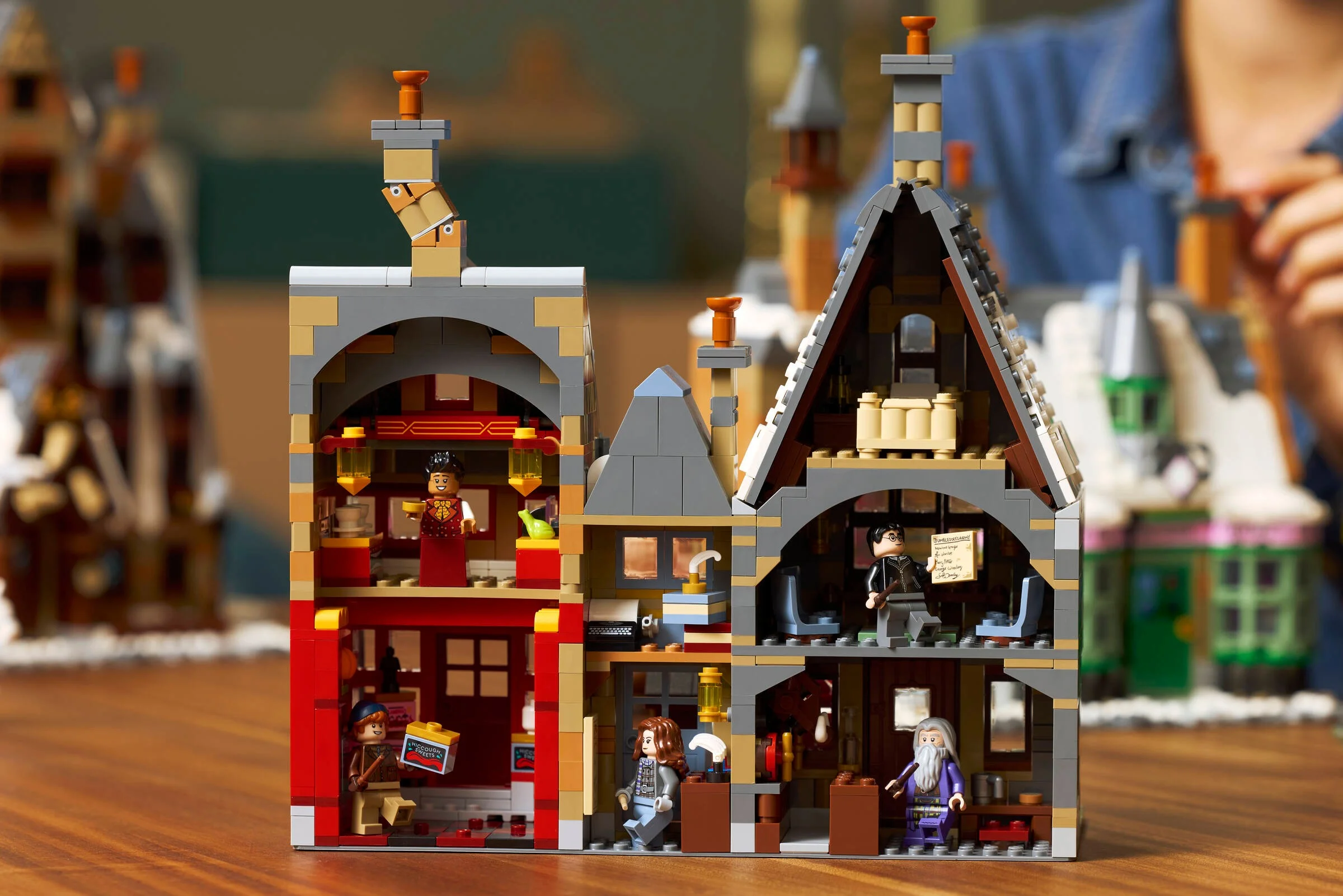 Secțiune printr-un model LEGO Hogsmeade, cu minifigurine și detalii interioare vizibile.