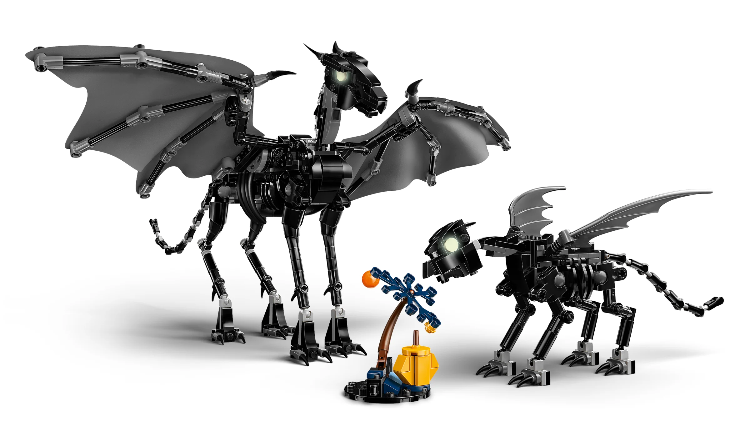 Două thestrale LEGO, adult și pui, lângă o plantă ciudată. Construcție detaliată, captivantă.