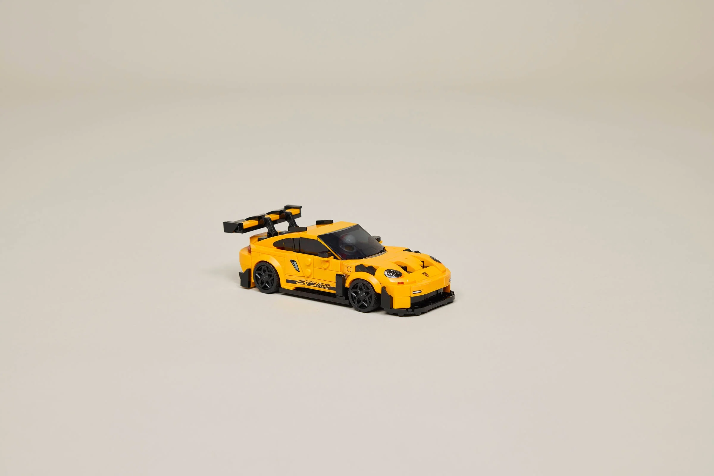 Modelul LEGO Porsche 911 GT3 RS, galben, cu aripă spate detaliată și design elegant.