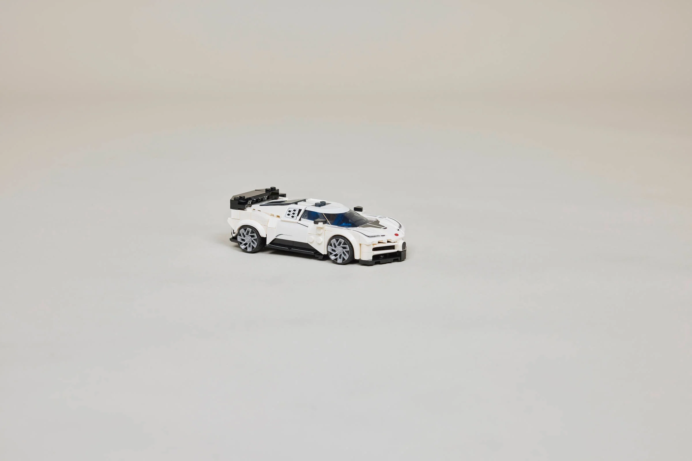 Modelul Bugatti Centodieci alb, realizat din piese LEGO. Detaliu: aripă spate neagră.