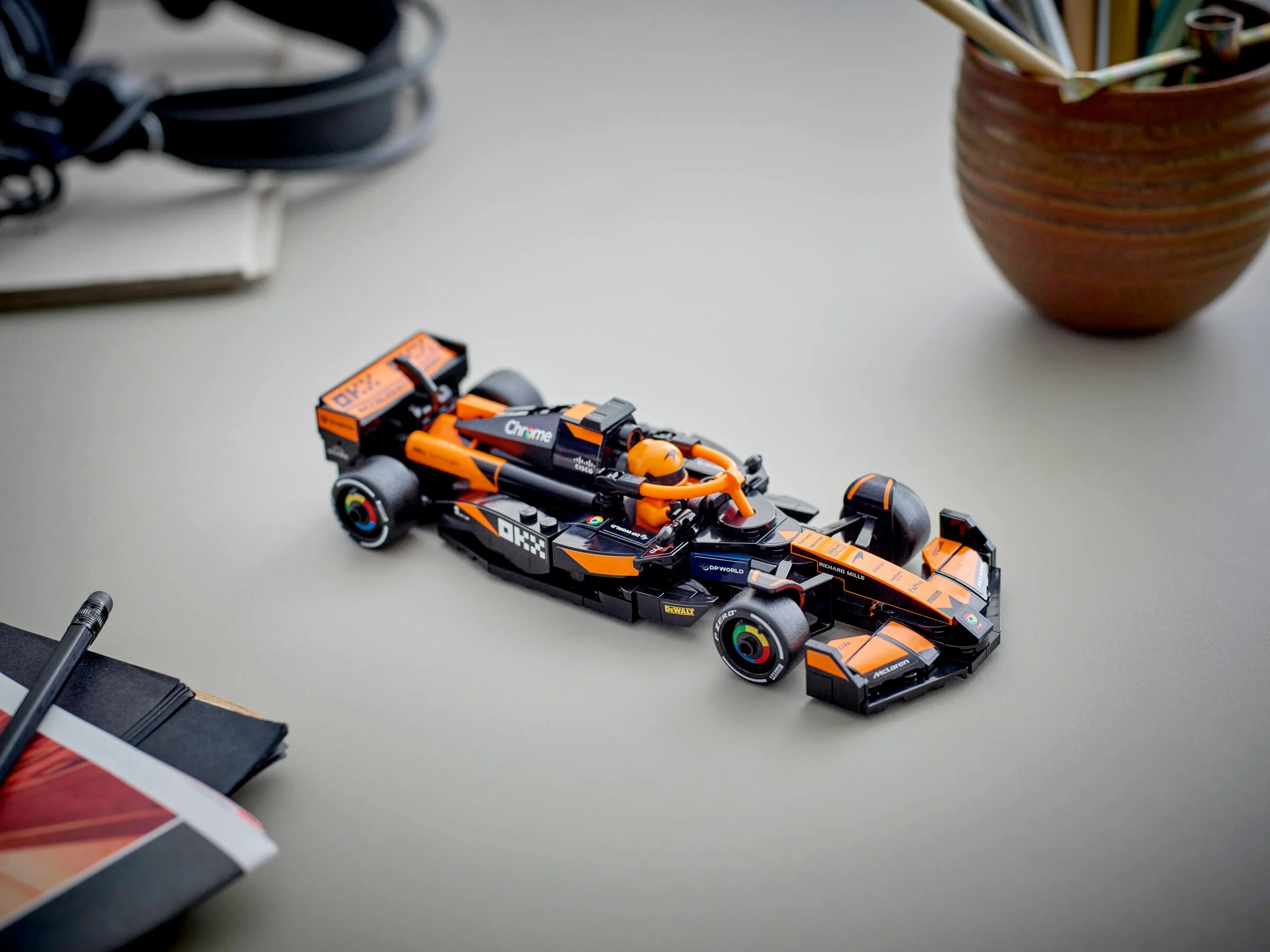 Modelul LEGO McLaren F1 MCL38, negru și portocaliu, surprins într-o fotografie de prezentare.