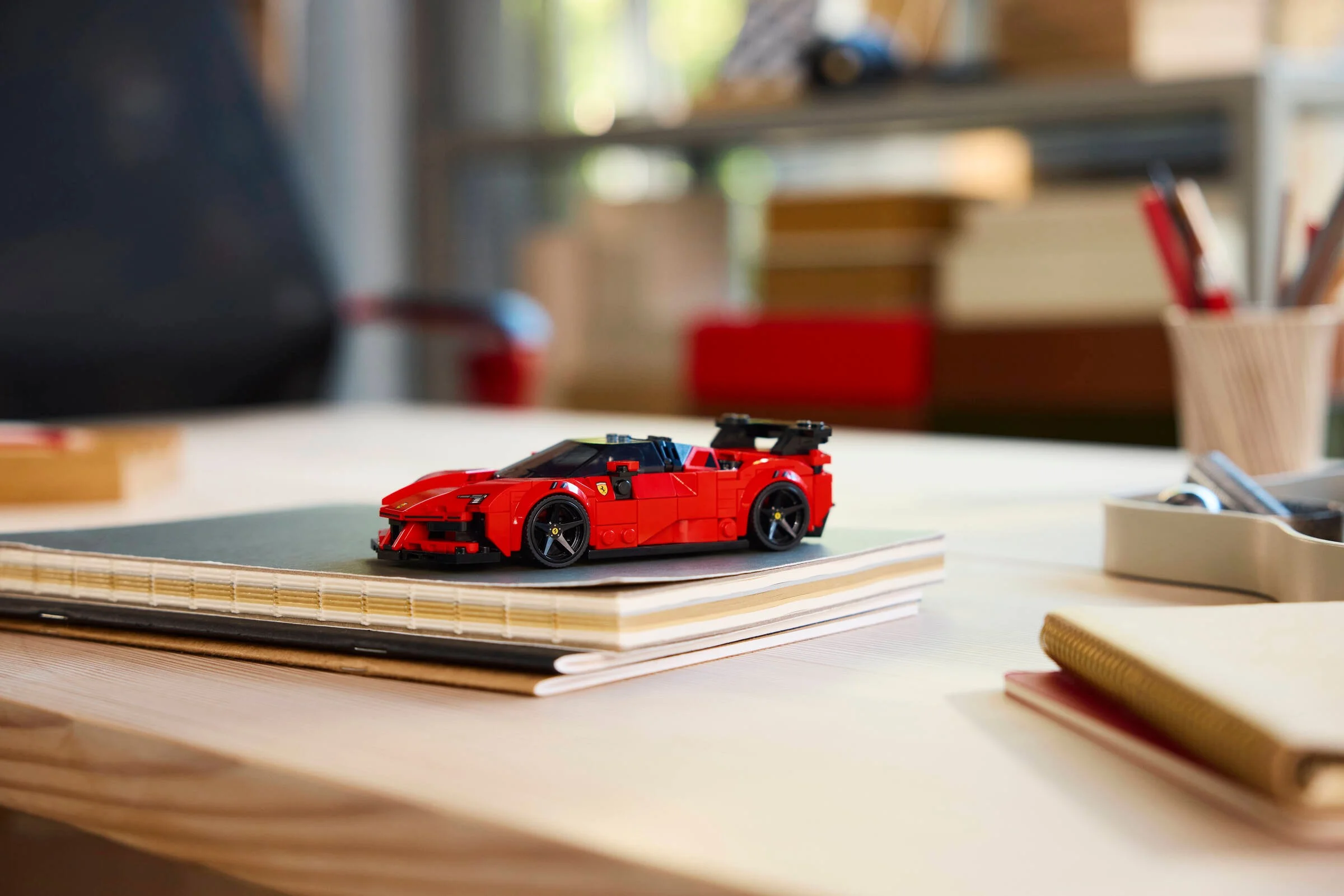 Ferrari SF90 XX Stradale LEGO roșu, pe o carte. Model detaliat, frumos.