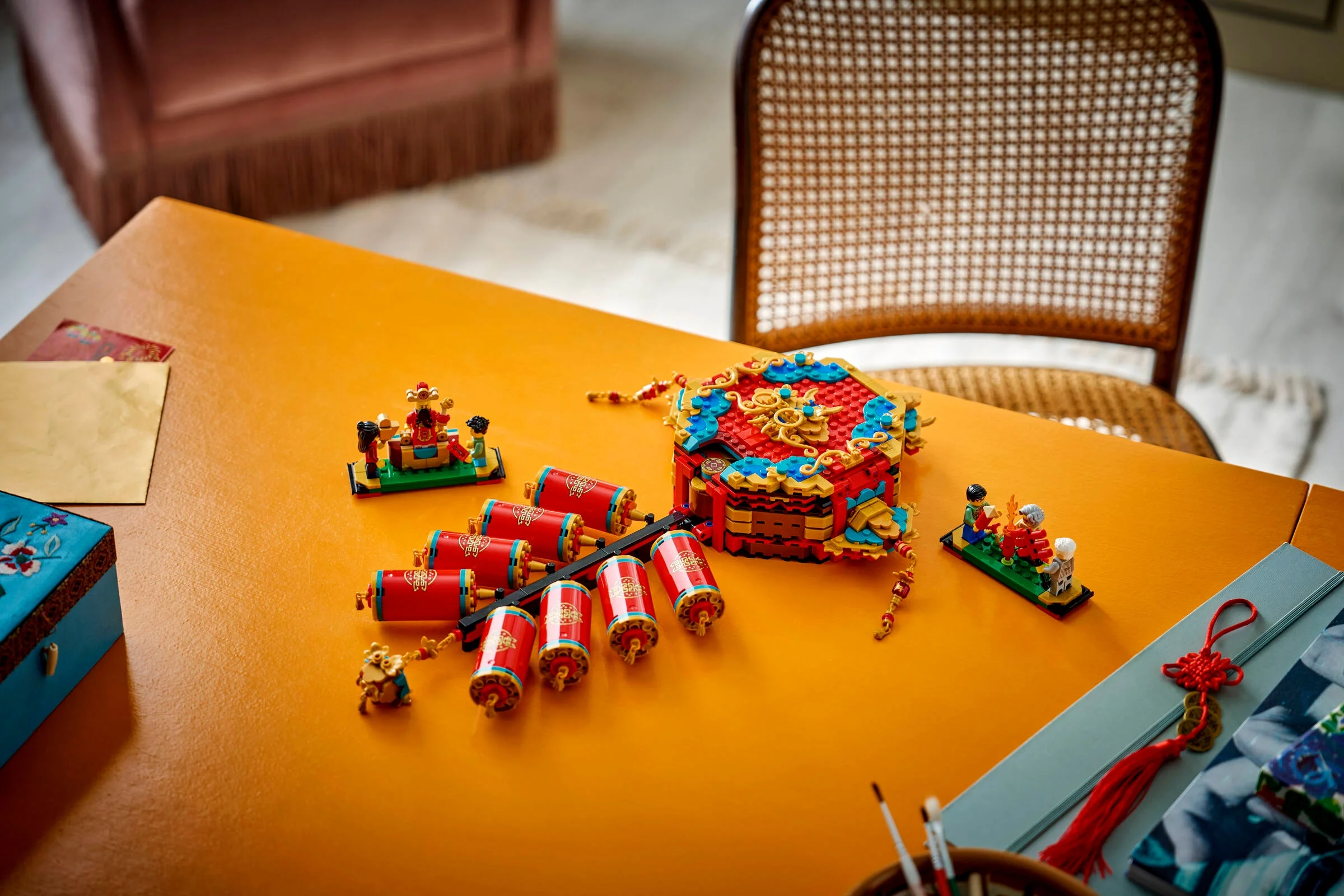 Imagine cu setul LEGO 80118 Fortune Firecracker, aranjat artistic pe o masă galbenă.