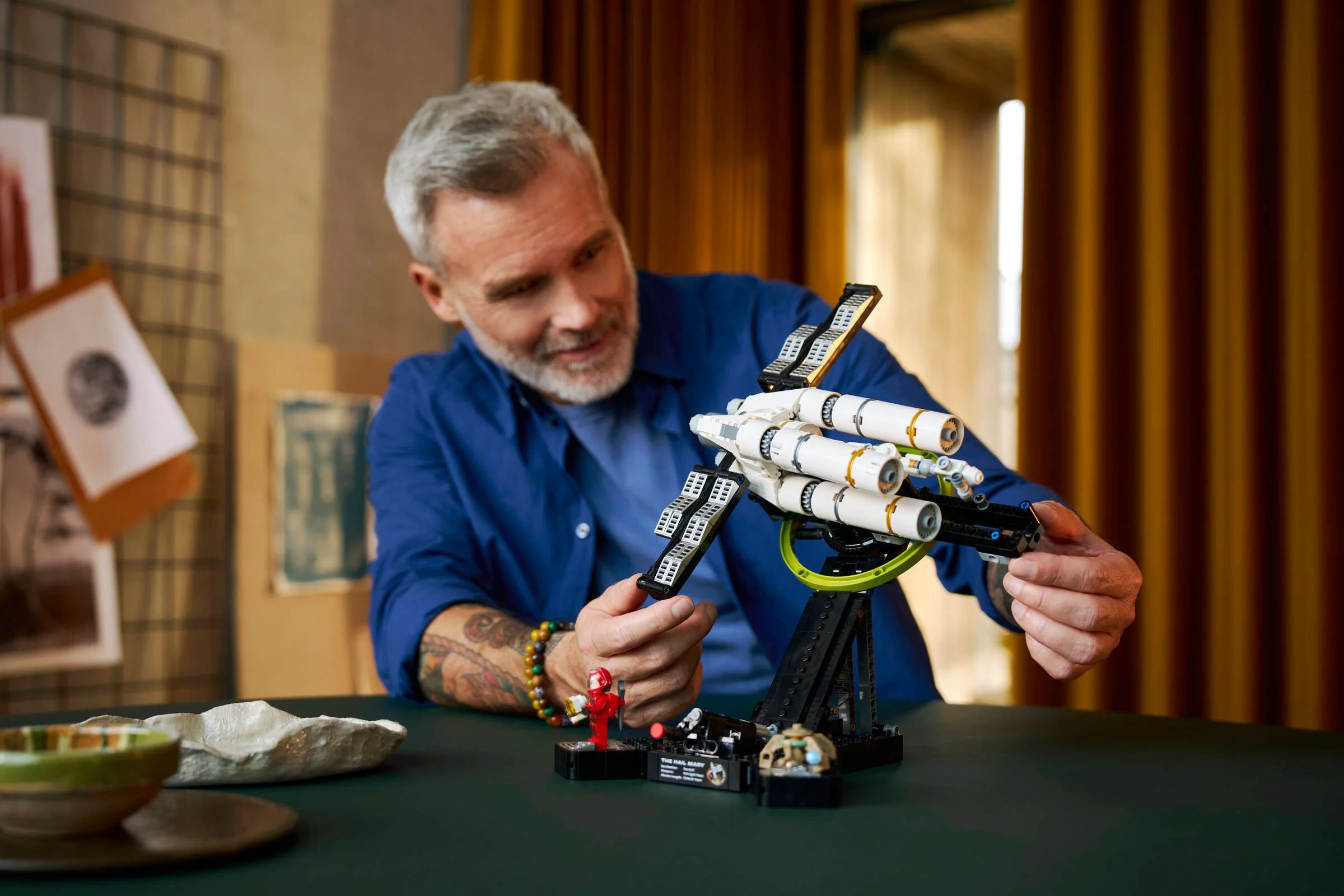 Bărbat interacționând cu modelul LEGO Project Hail Mary.