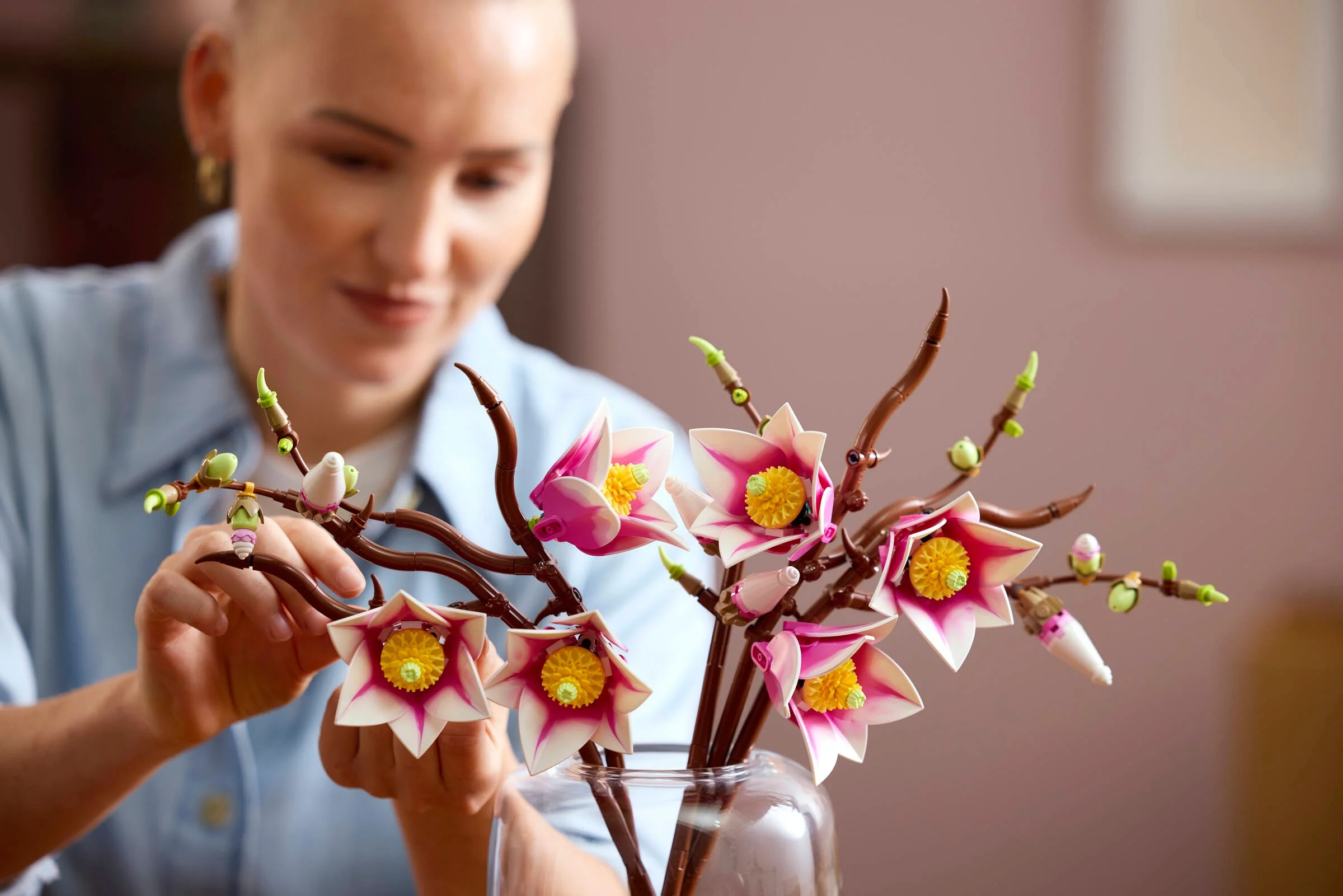 Ramuri de magnolie LEGO 11510 într-o vază, aranjate cu grijă de o persoană.