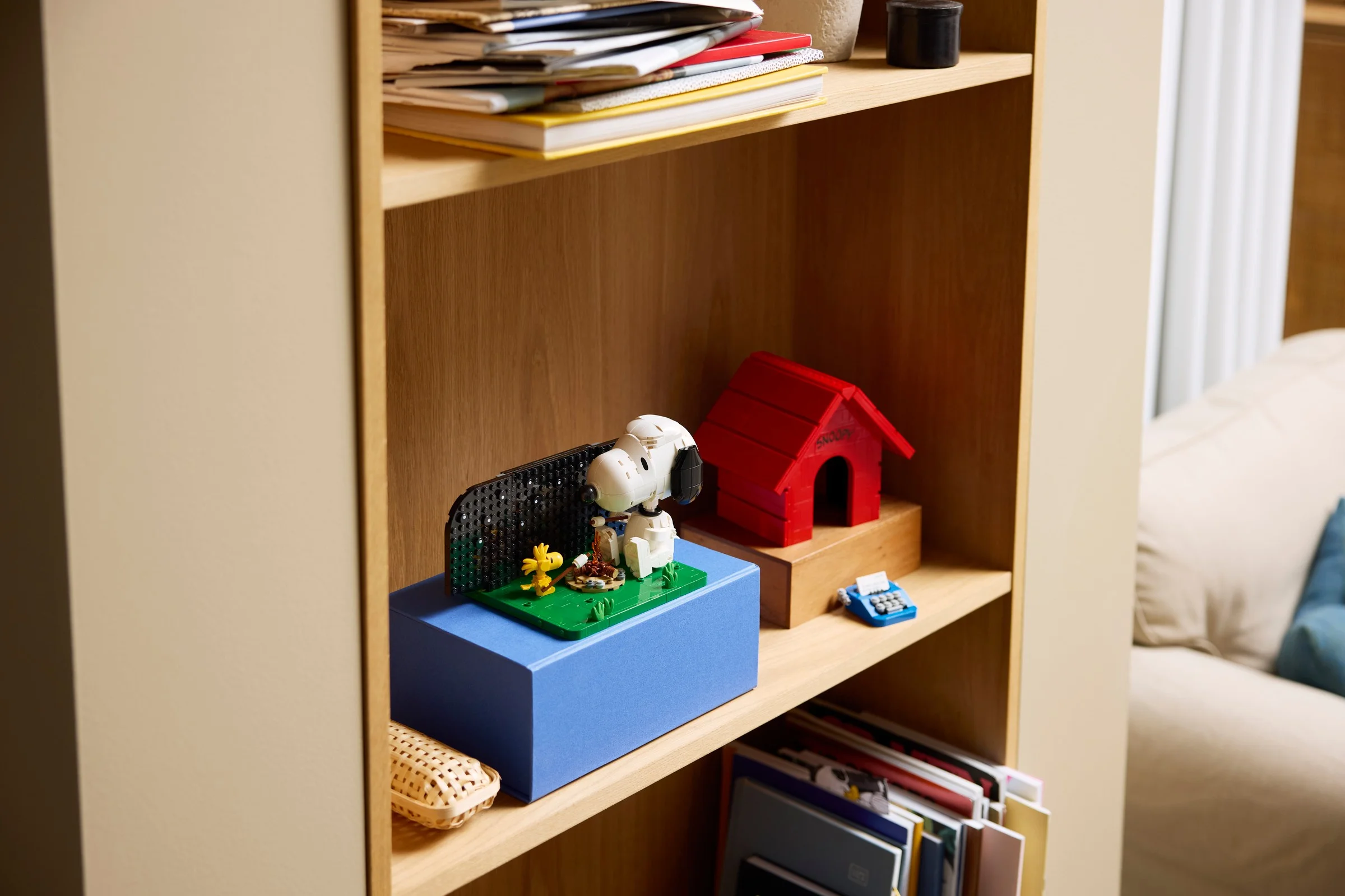 Modelul LEGO Snoopy's Doghouse expus pe un raft. Atmosferă caldă și prietenoasă.